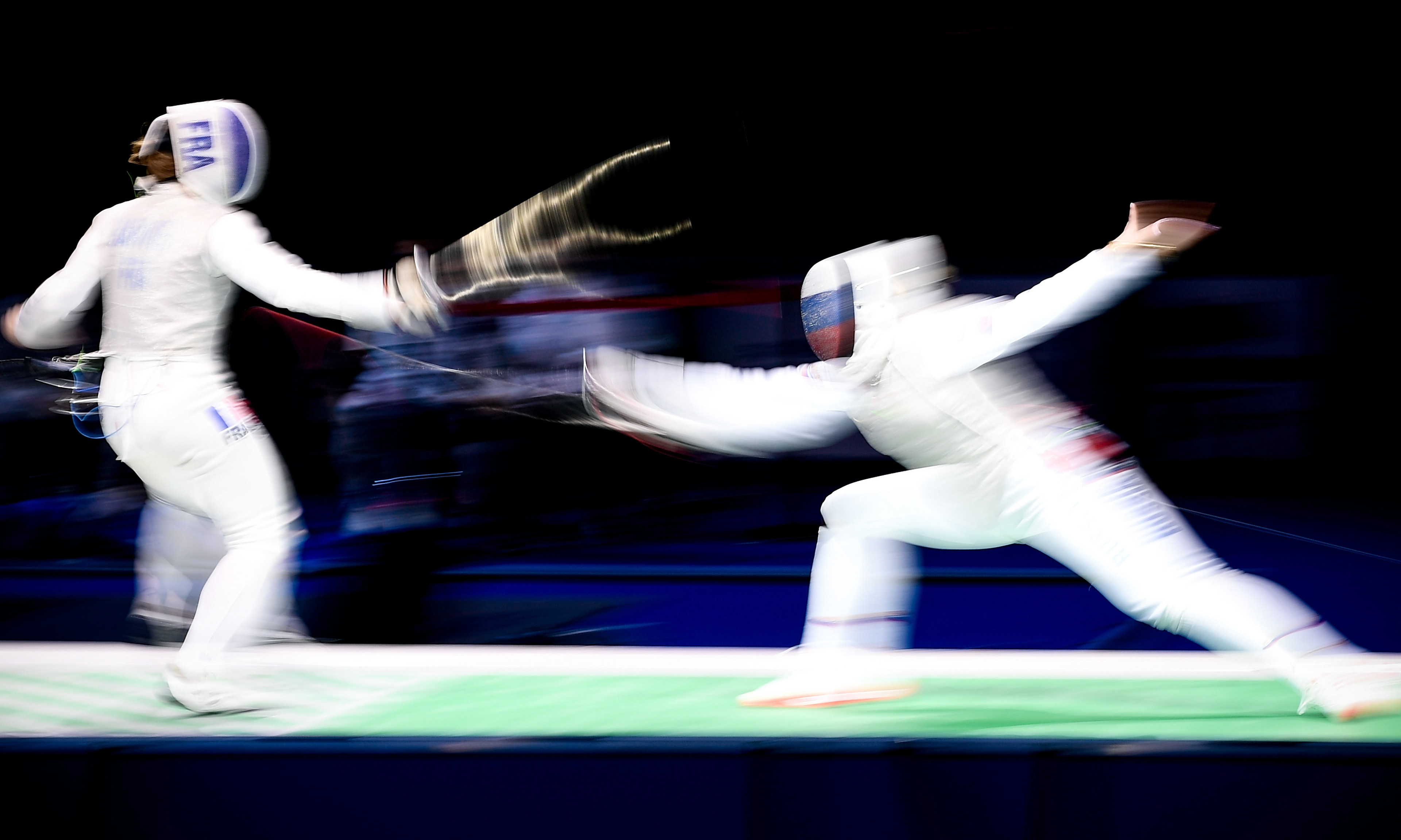 A long time exposure showing athletes of France (L) and Russia (R) competing in the foil women's team final of the 2019 Fencing European Championships in Duesseldorf, Germany, 21 June 2019. (Photo by Sascha Steinbach/epa)