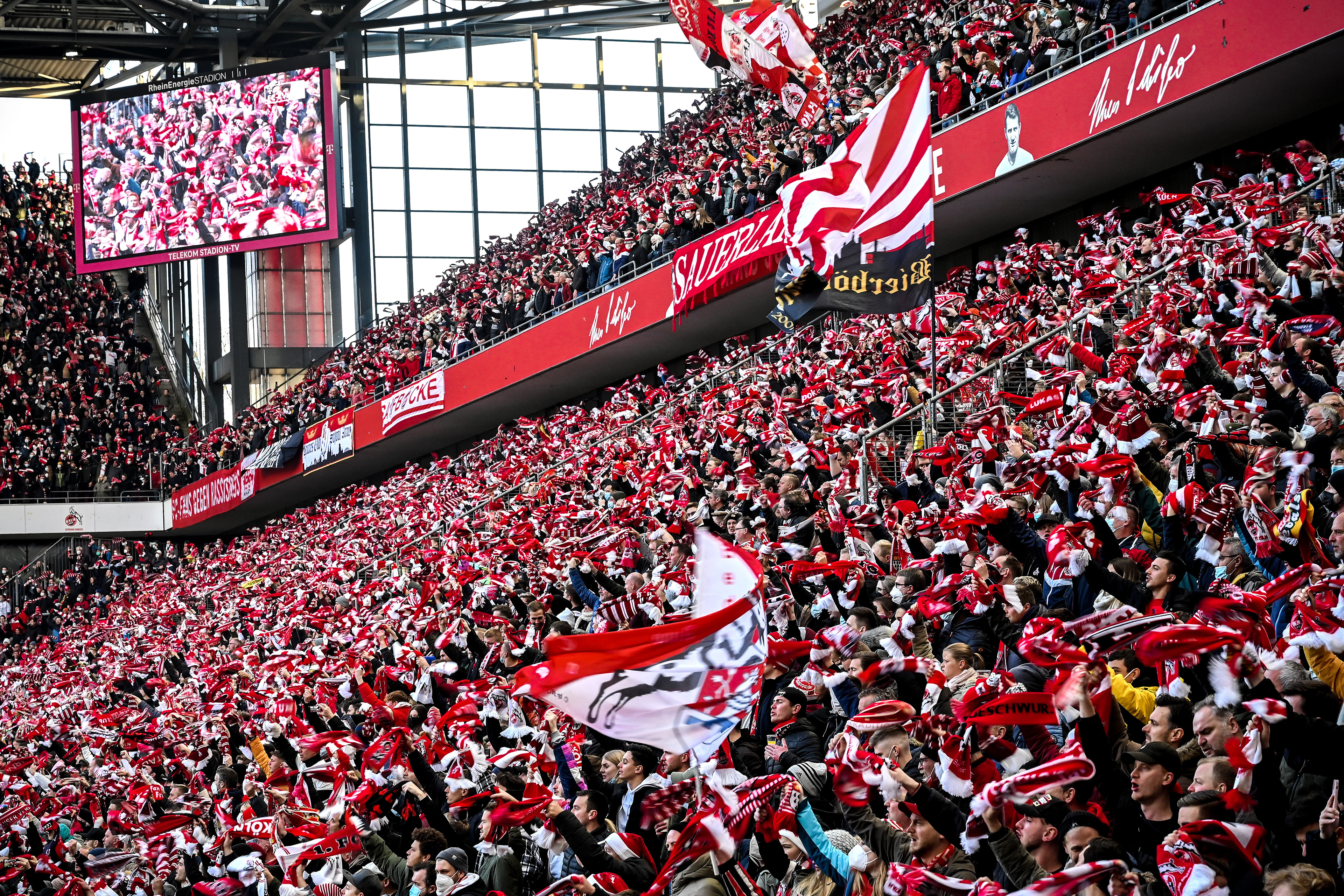Fans in the stands wave their scarfs as they stand close together prior to the German Bundesliga soccer match between 1. FC Koeln and Borussia Moenchengladbach at Rheinenergiestadion in Cologne, Germany, 27 November 2021. (Photo by Sascha Steinbach/epa)