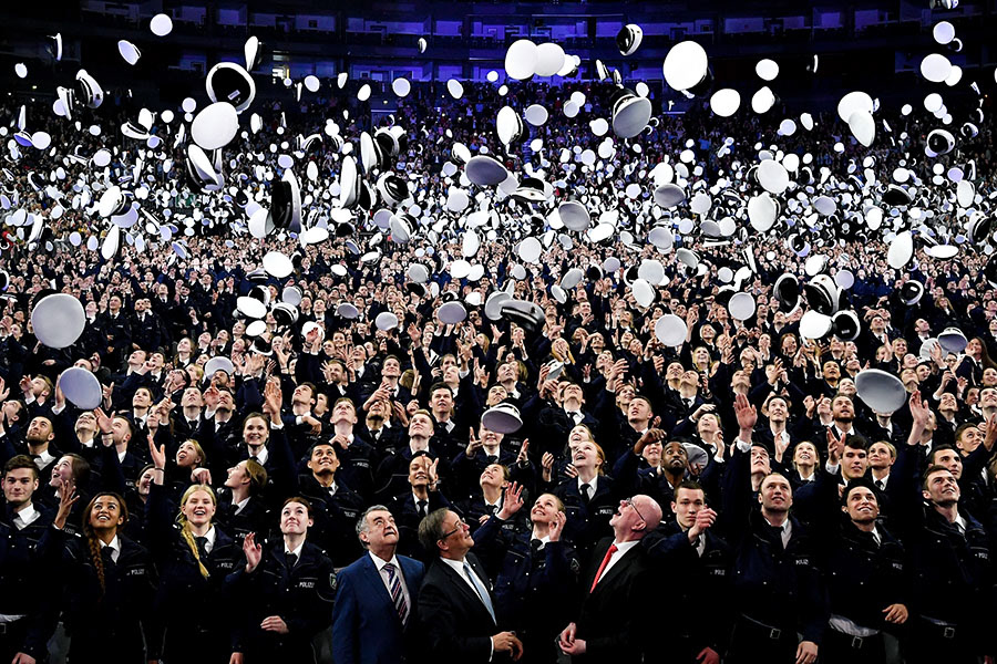 2,300 police officers throw their caps in the air after taking their oath of allegiance to the state constitution at Lanxess Arena in Cologne, Germany, 03 April 2019. (Photo by Sascha Steinbach/epa)