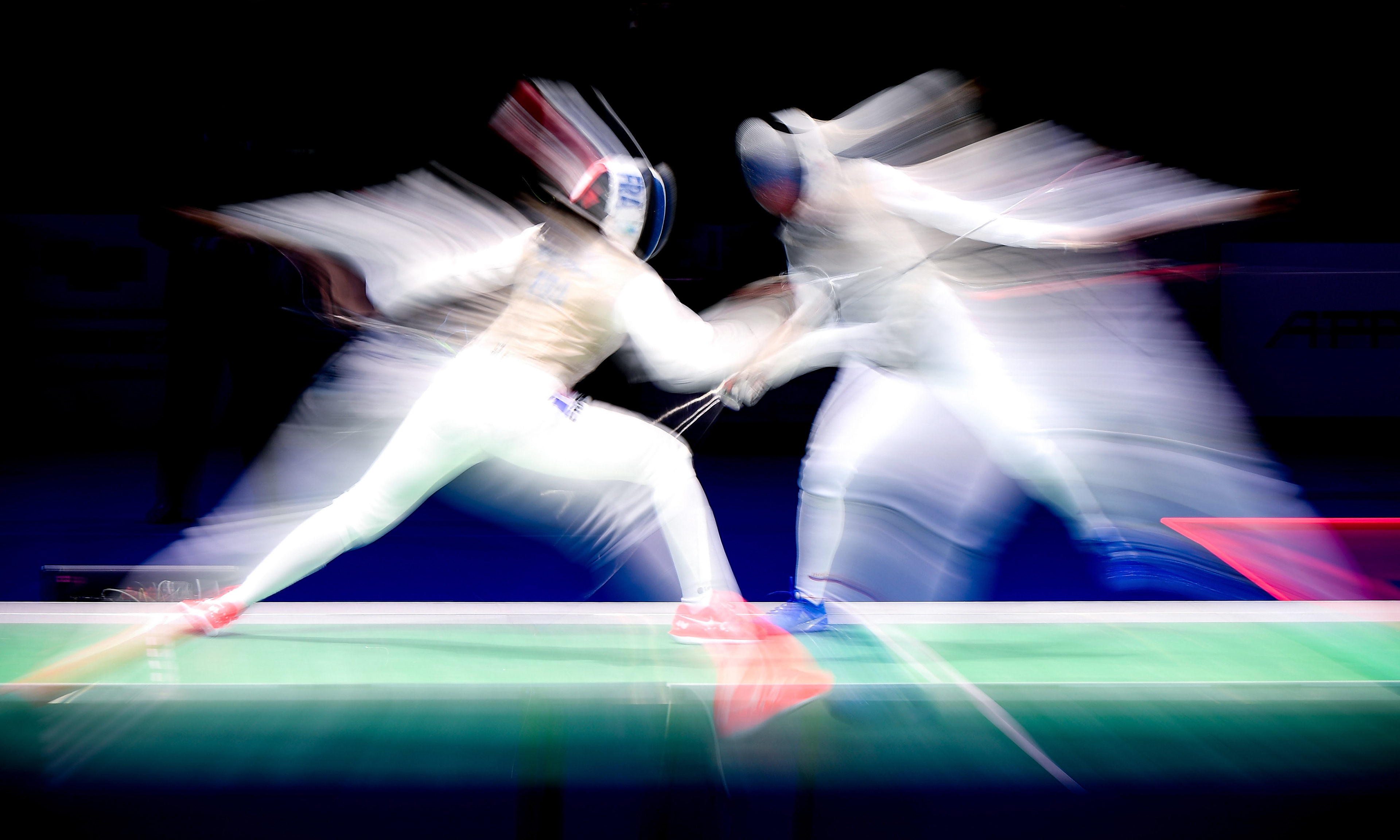 A long time exposure showing athletes of France (L) and Russia (R) competing in the foil women's team final of the 2019 Fencing European Championships in Duesseldorf, Germany, 21 June 2019. (Photo by Sascha Steinbach/epa)