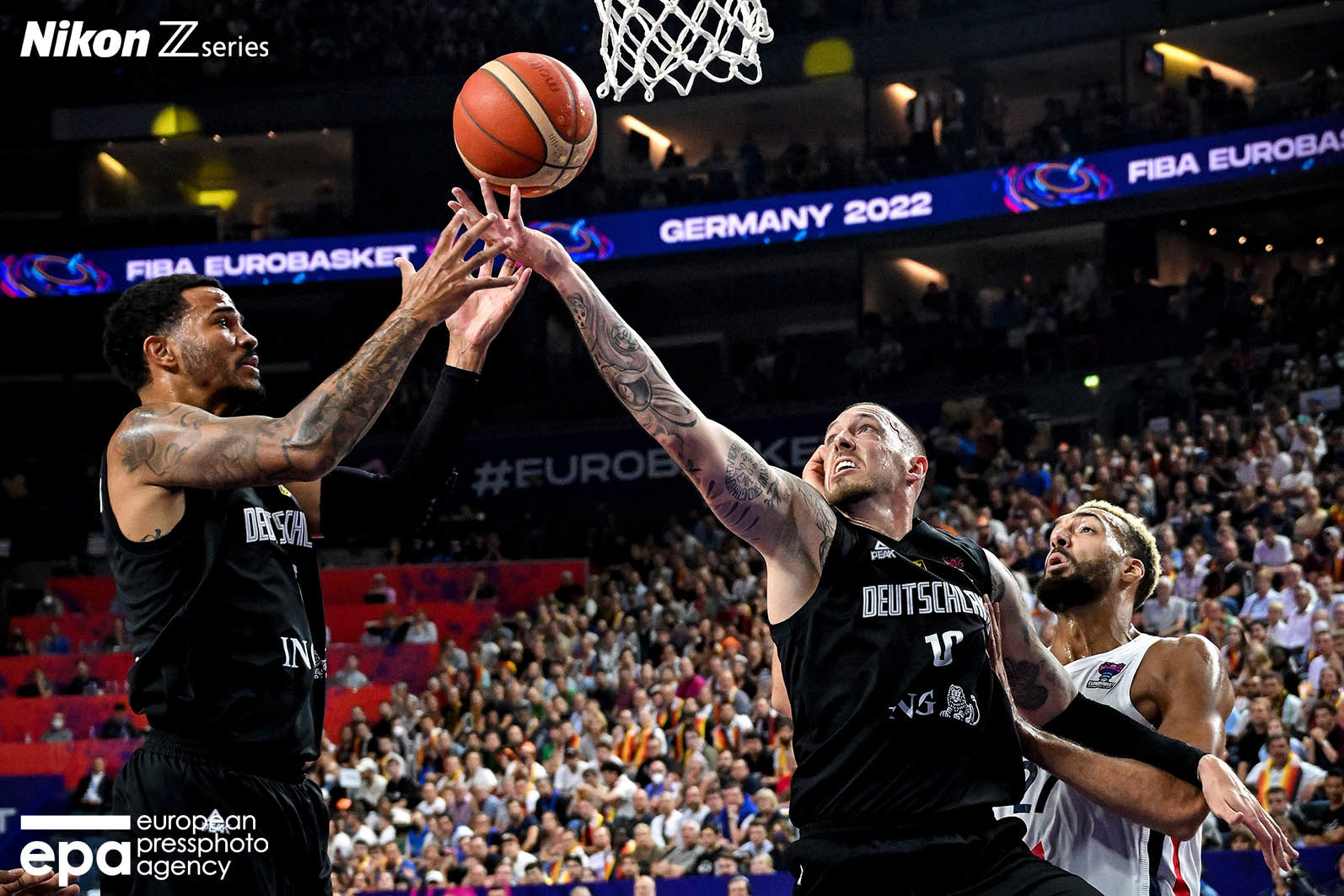 Daniel Theis (C) and Nick Weiler-Babb (L) of Germany in action against Rudy Gobert of France (R) during the FIBA EuroBasket 2022 group B stage match between France and Germany in Cologne, Germany, 01 September 2022.
