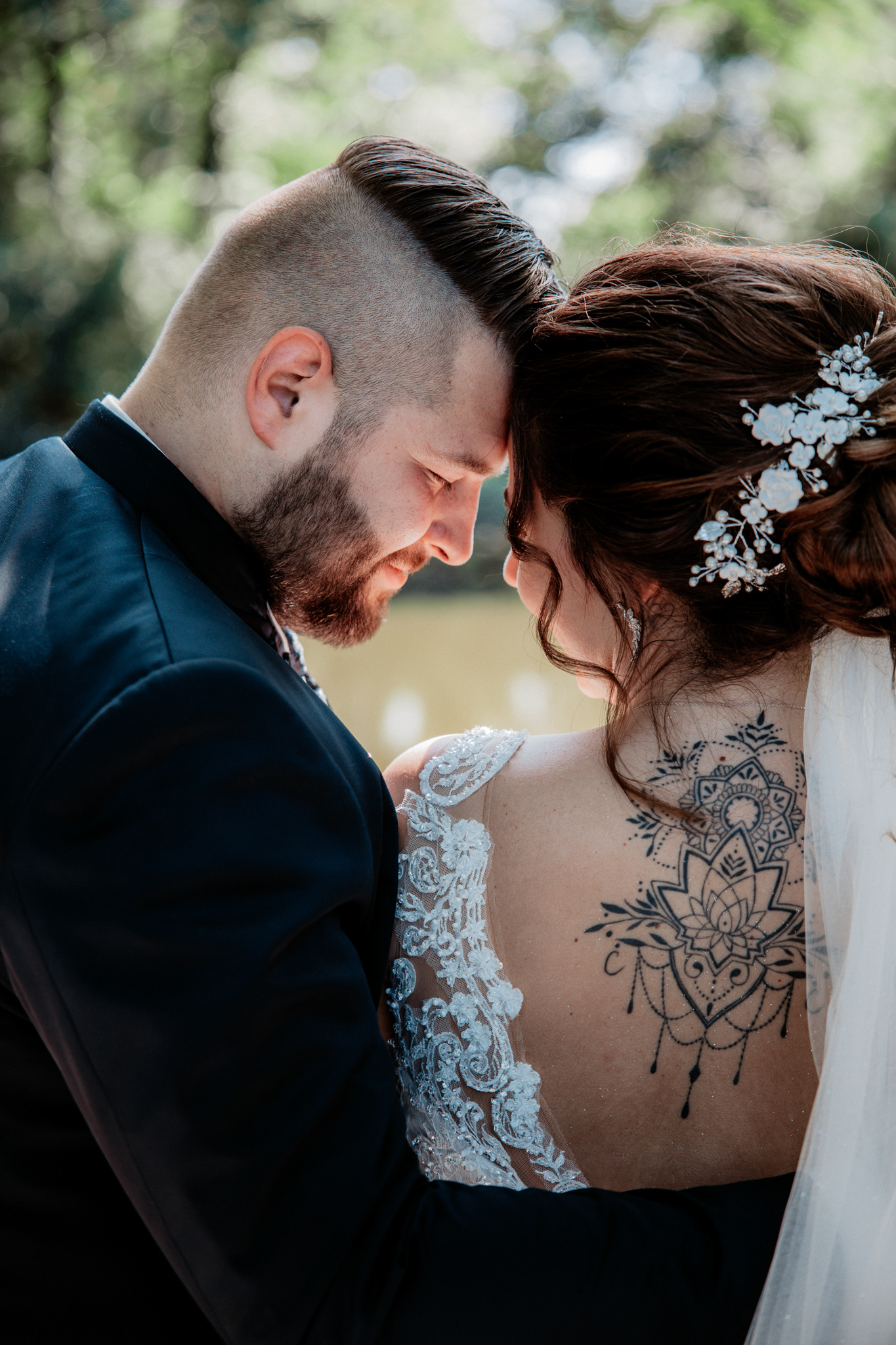 Inniger Moment: Michael lehnt seine Stirn an Denise' während eines romantischen Brautpaar-Shootings, ihr Tattoo und Haarschmuck kommen zur Geltung.