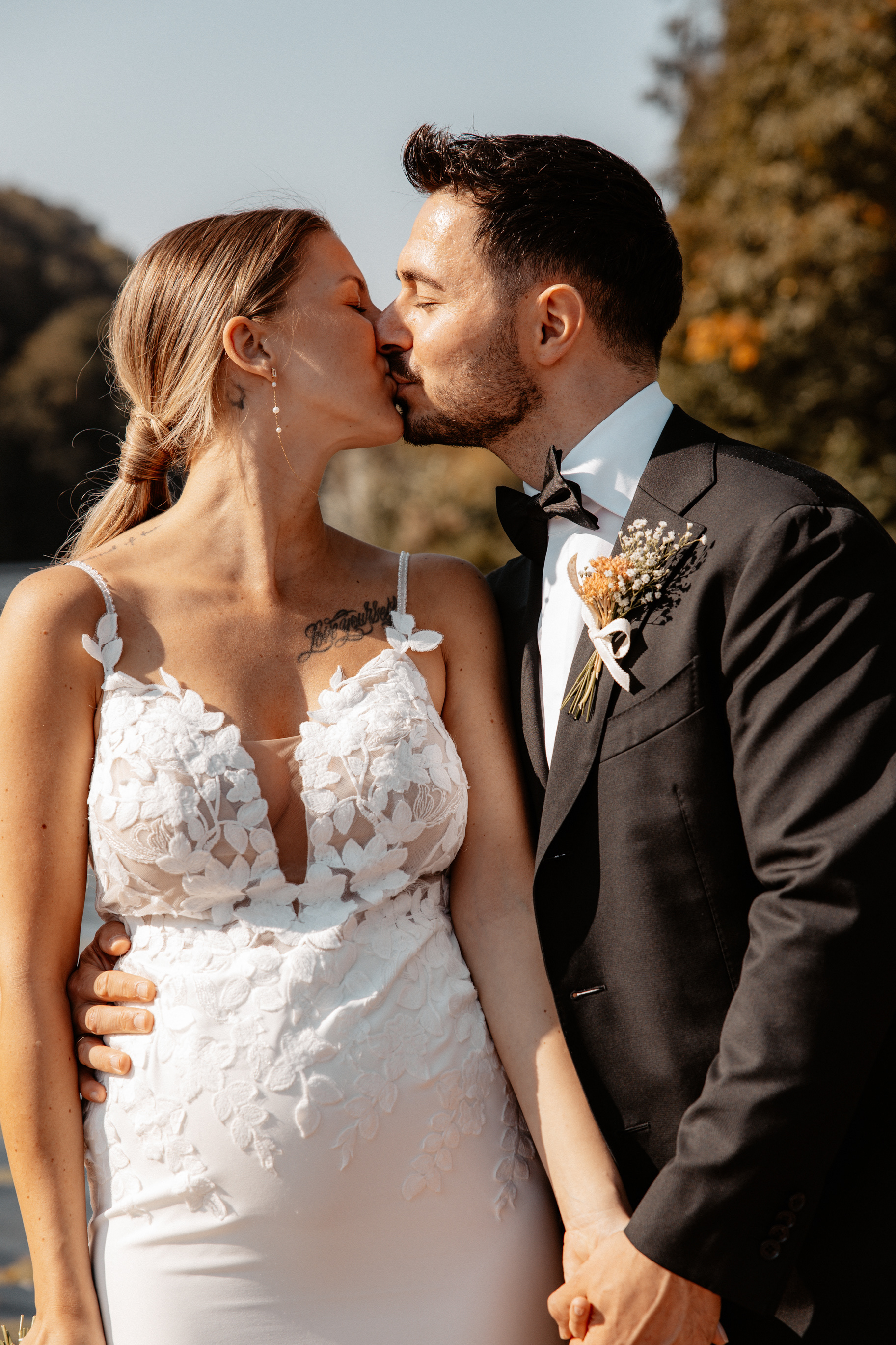 Inniger Kussmoment zwischen Justine und Maurice vor einer idyllischen Kulisse, beide strahlen vor Glück.