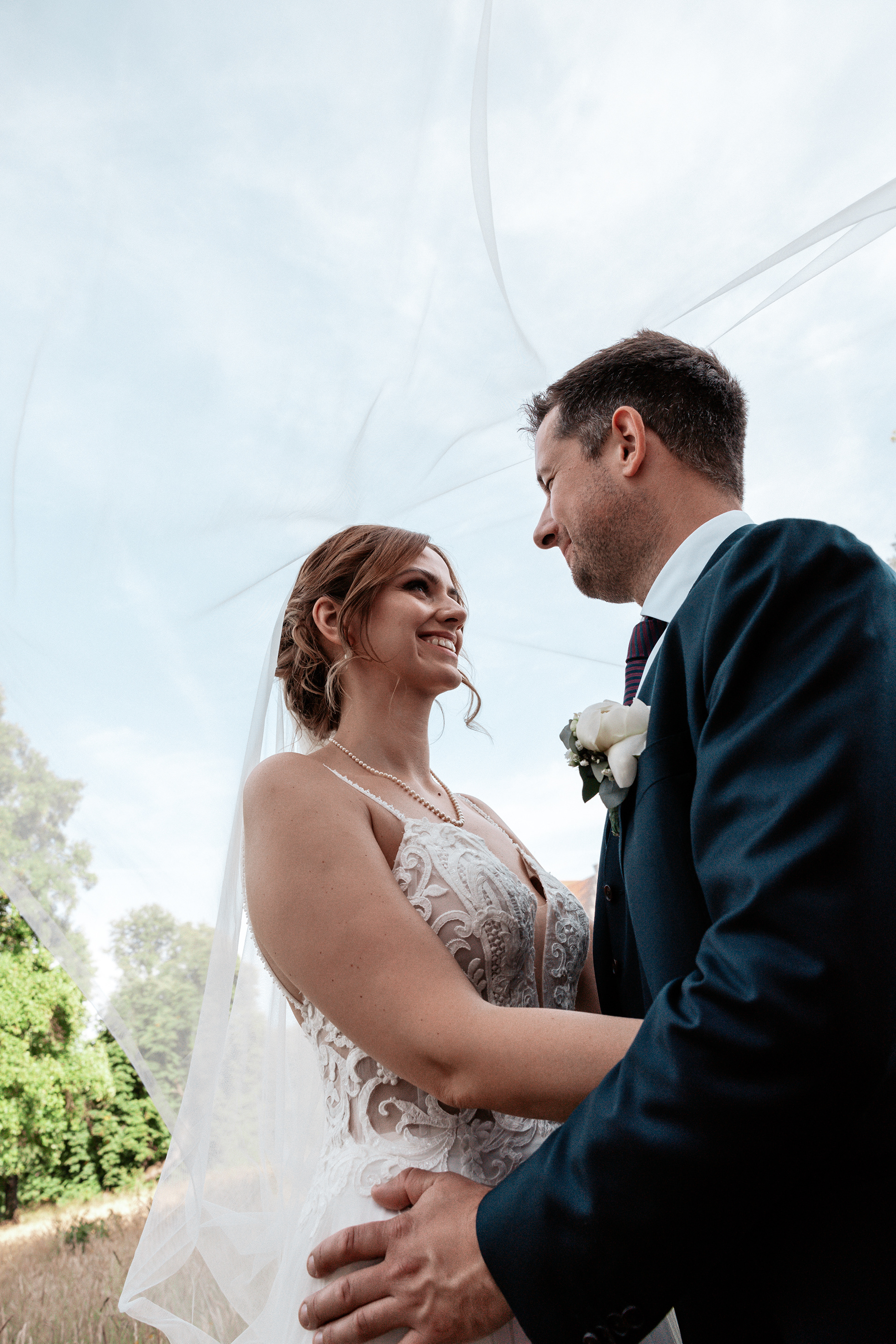 Christina und Phillip Hochzeitsfoto Nahaufnahme unter dem Schleier. Die sanfte Lichtstimmung und die Nähe des Paares machen dieses Bild besonders emotional.