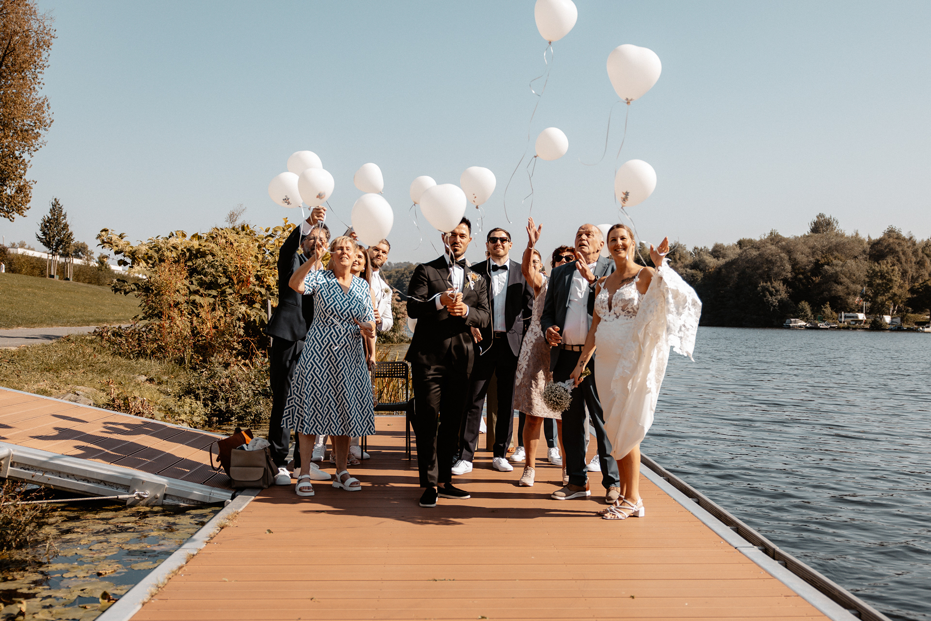 Der Moment des Loslassens – die Hochzeitsgäste lassen ihre weißen Ballons in den Himmel steigen, während das Brautpaar strahlt.