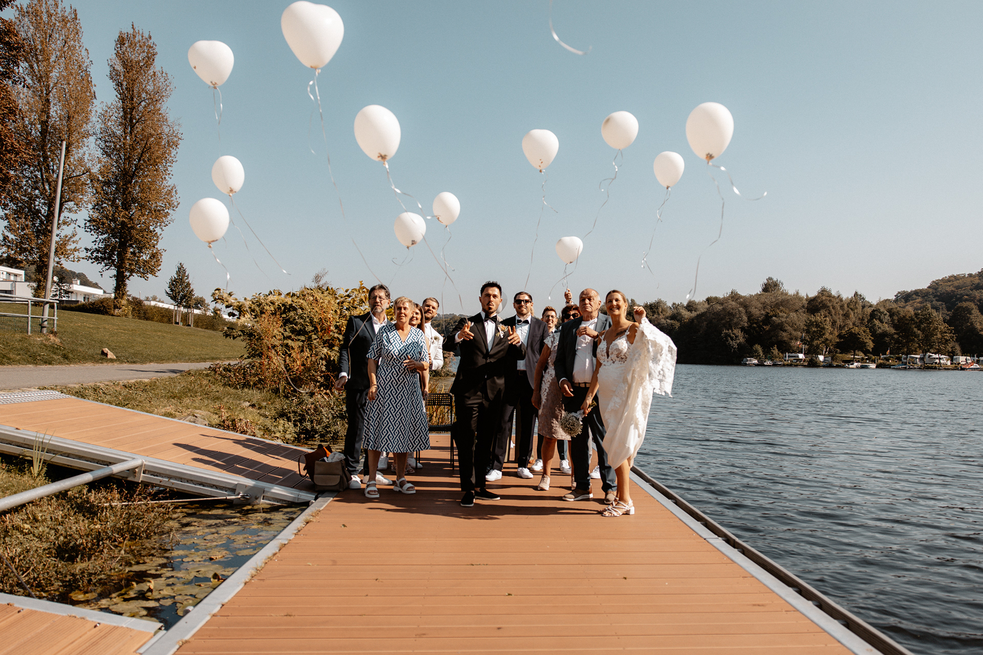 Luftaufnahme der schwebenden weißen Ballons über dem Wasser, ein Symbol für Wünsche und Glück.