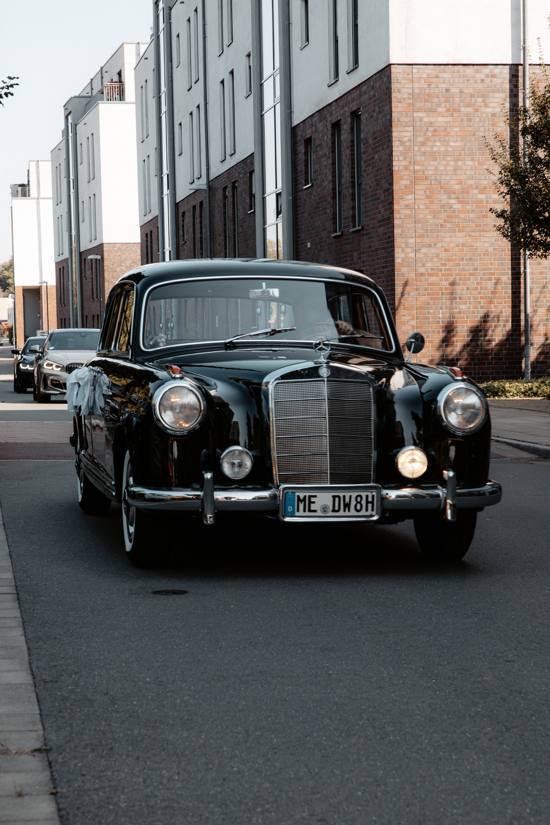 Ein klassischer schwarzer Mercedes Oldtimer vor um das Brautpaar abzuholen.