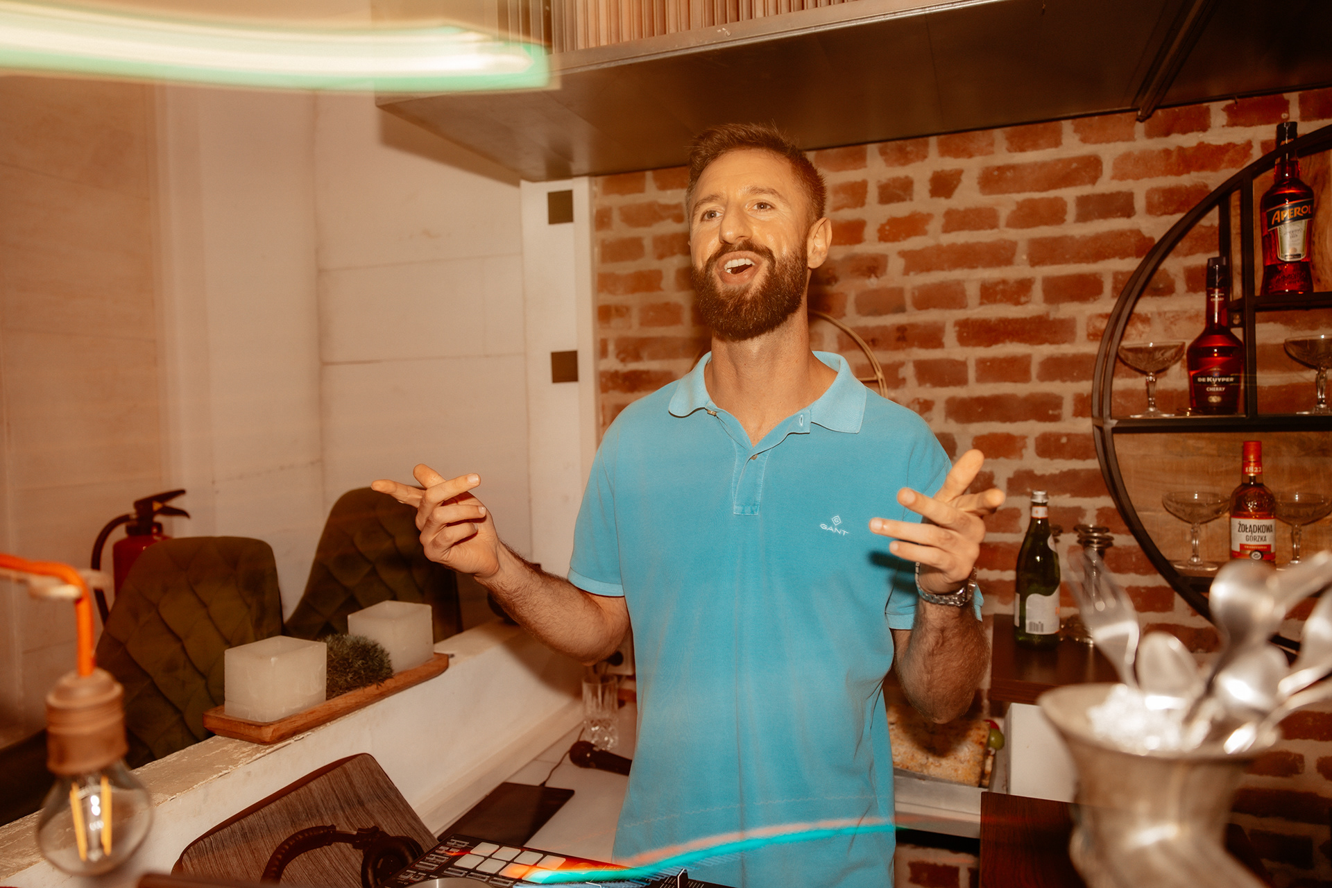 Der DJ der Hochzeit steht hinter seinem Mischpult, trägt ein blaues Polo-Shirt und verbreitet mit seiner positiven Ausstrahlung Partystimmung