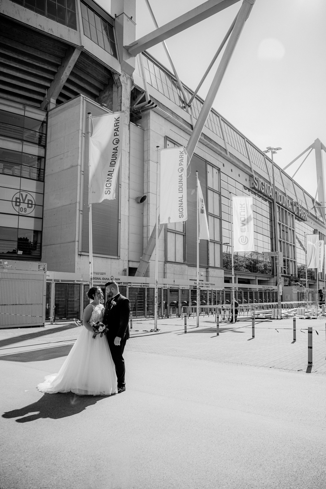 Das Brautpaar posiert vor dem Signal Iduna Park in Dortmund – ein besonderer Ort für ihre Hochzeitsfotos.