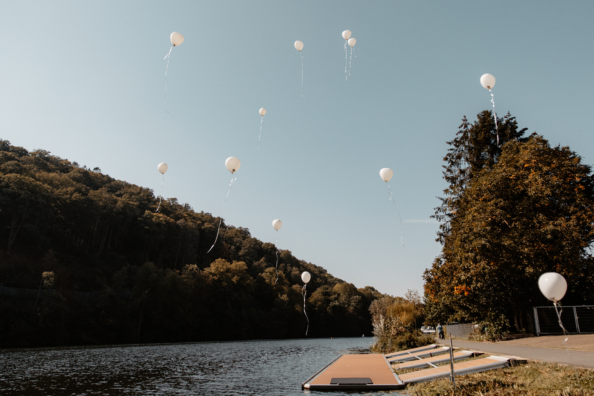 Luftaufnahme der schwebenden weißen Ballons über dem Wasser, ein Symbol für Wünsche und Glück.
