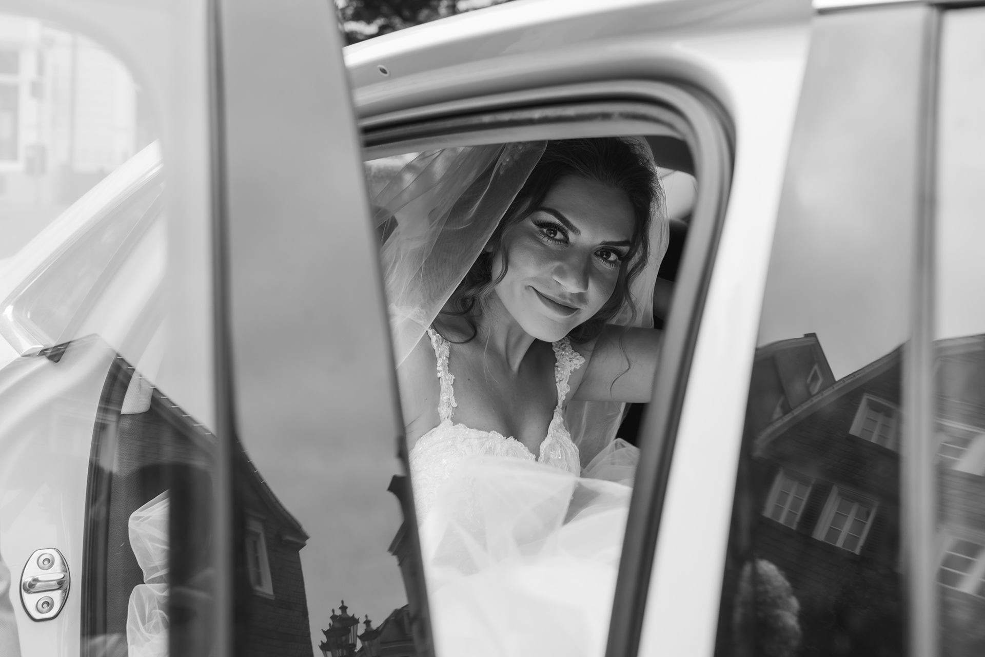Schwarz-Weiß-Hochzeitsfoto von Özge beim Aussteigen aus dem Wagen.