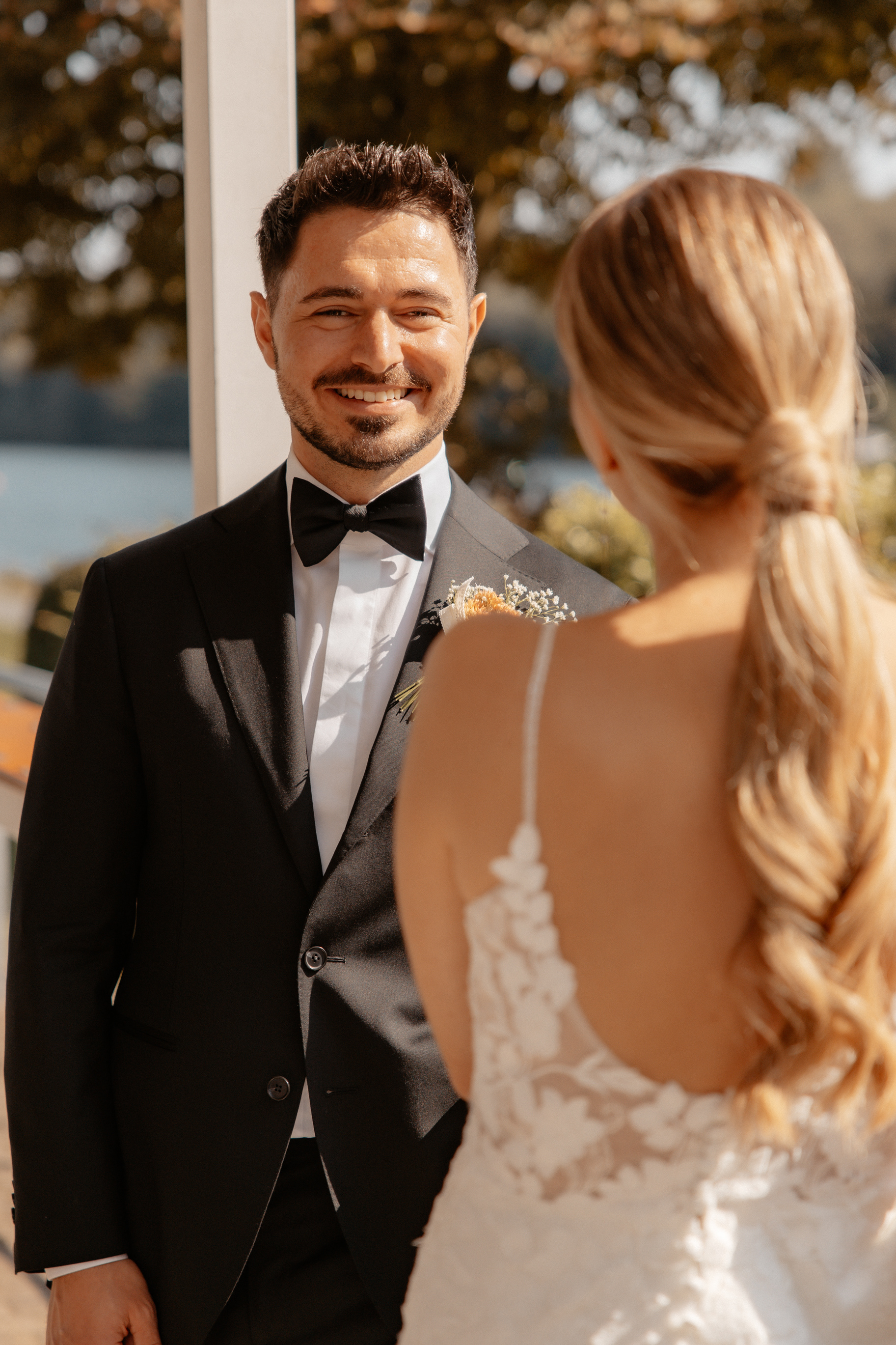 Eine Nahaufnahme des Bräutigams, der voller Freude und Stolz in die Kamera strahlt.