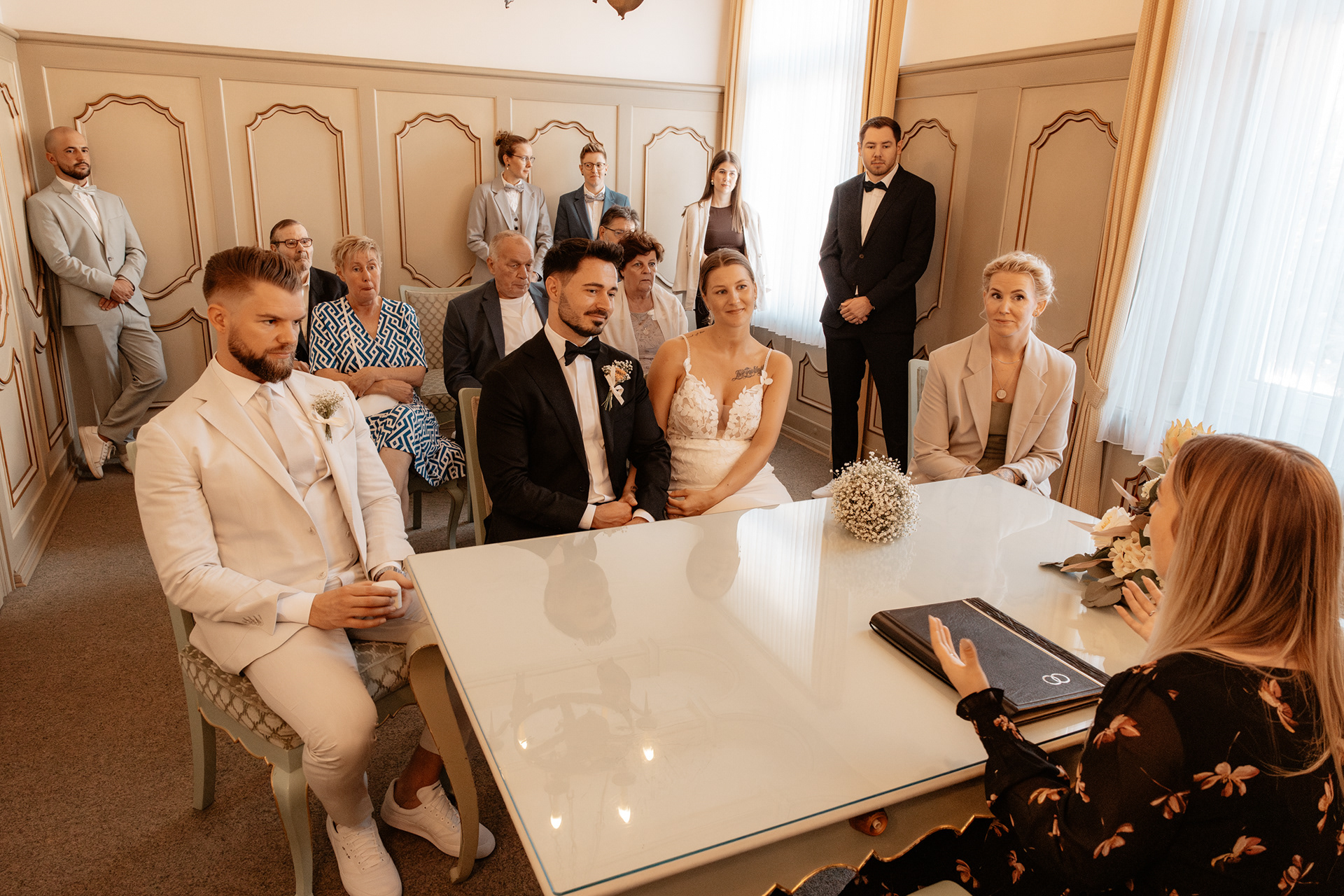 Brautpaar Justine und Maurice sitzen im Standesamt von Essen-Kettwig, umgeben von Familie und Freunden, während die Standesbeamtin die Trauung durchführt