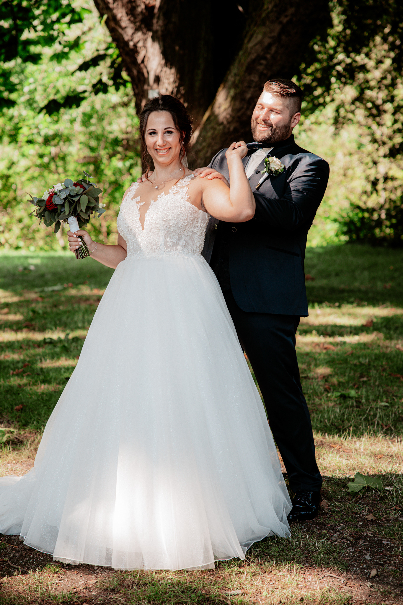 Spaß und Freude beim Hochzeitsshooting: Denise posiert spielerisch, während Michael sie mit einem Lächeln begleitet.