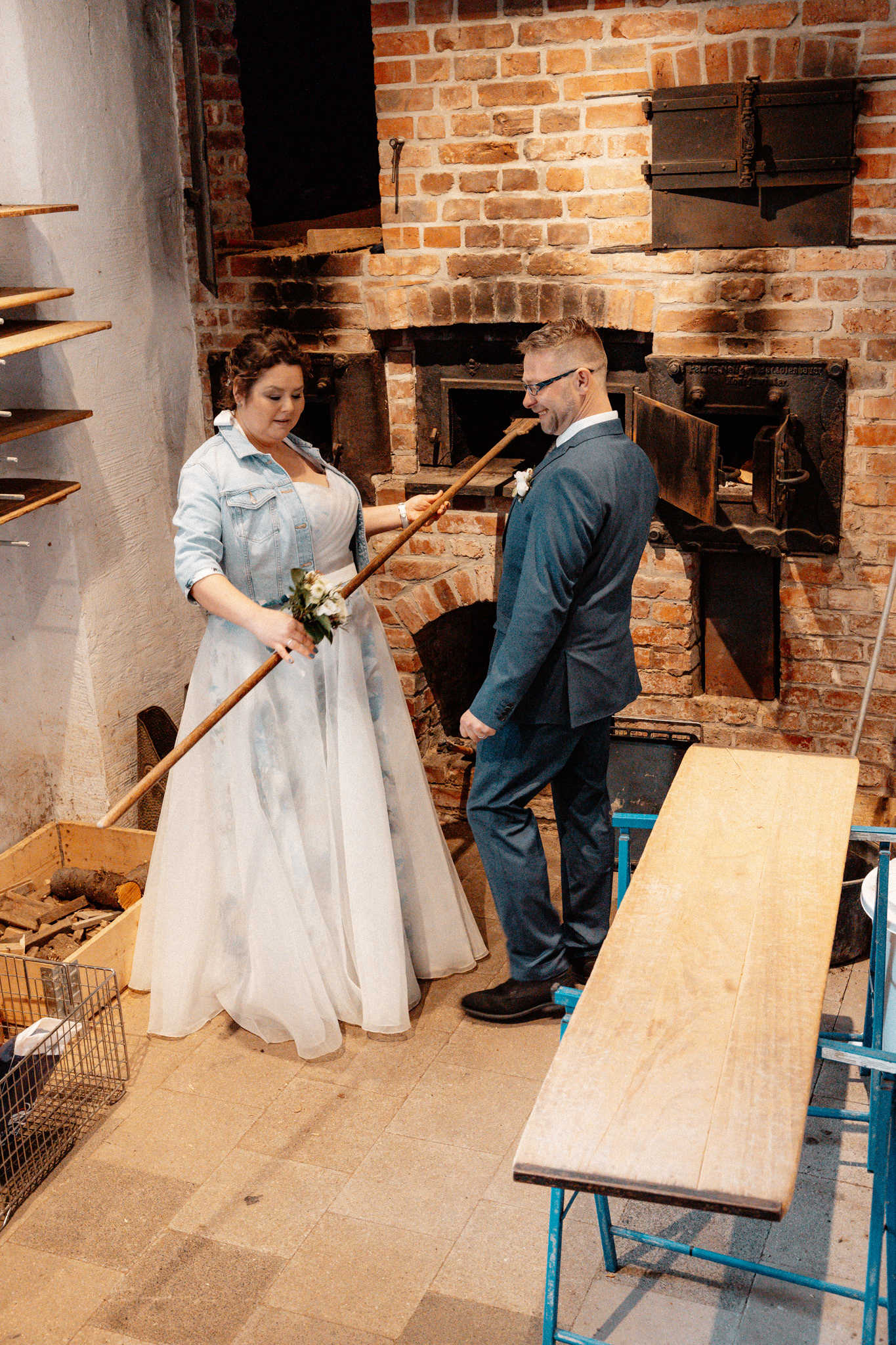 Claudia und Sven beim traditionellen Brotbacken in der historischen Goldberger Mühle, umgeben von rustikalen Backöfen.