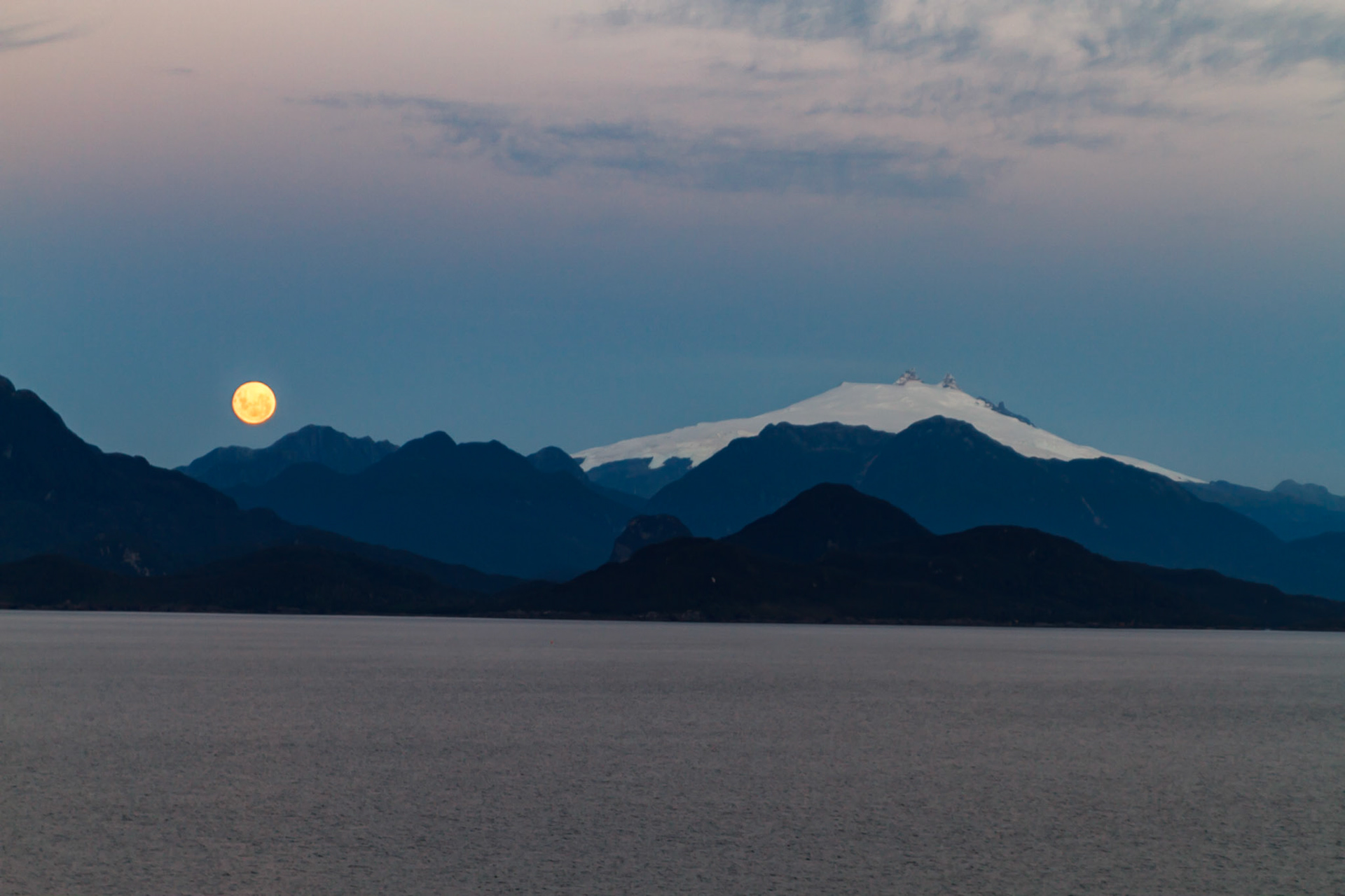 sun setting on one side and full moon rising on the other - Chilian Fjords