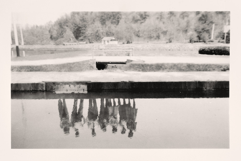 Traces: Group Standing by Water. Greg Sand.