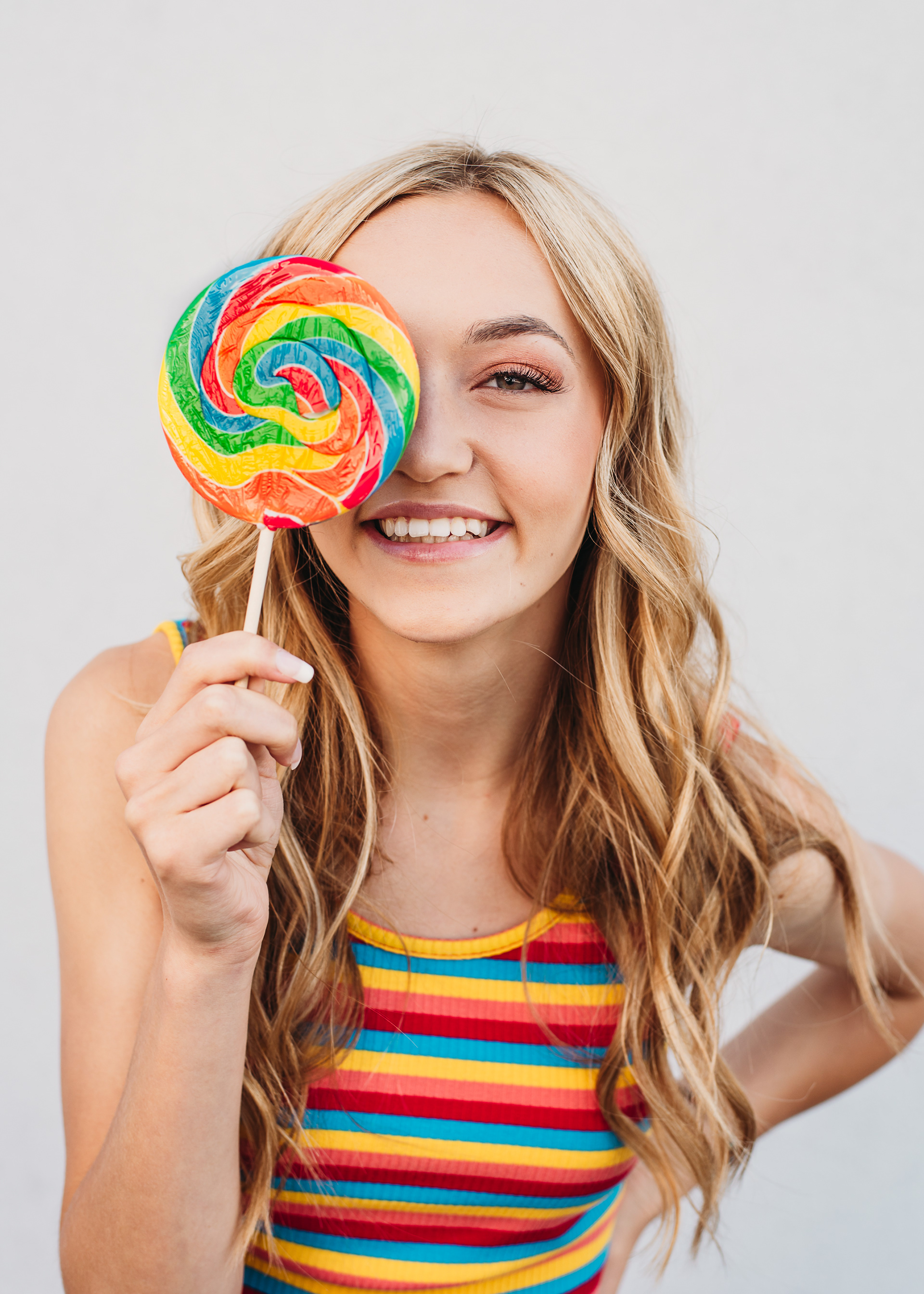 Candy inspired senior portrait photoshoot with striped top and rainbow lollipop