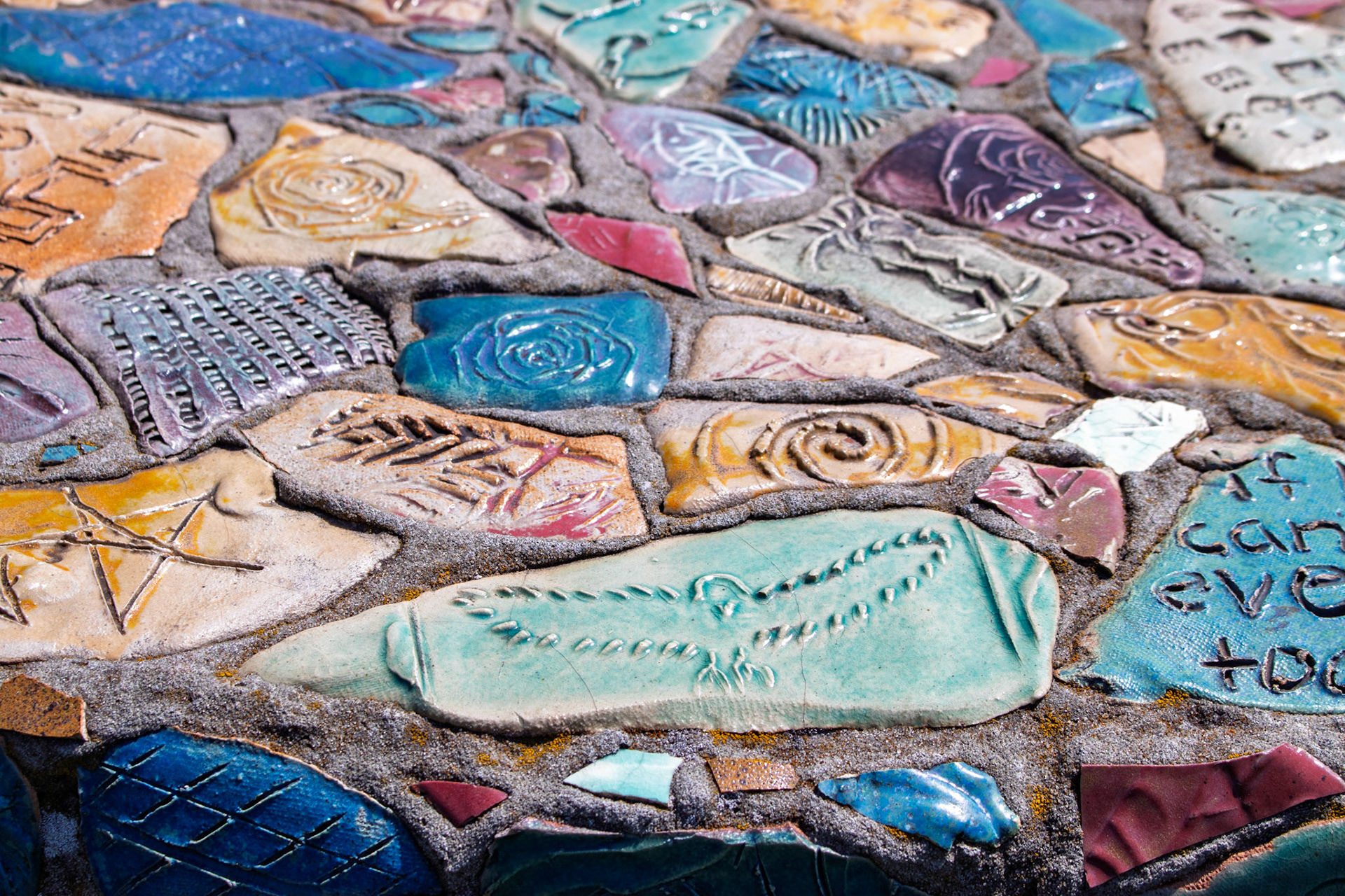 Tiles on benches that are part of a sculpture made by people incarcerated in MCF Shakopee between 1994 - 1995. Displayed at Franconia Sculpture Park.