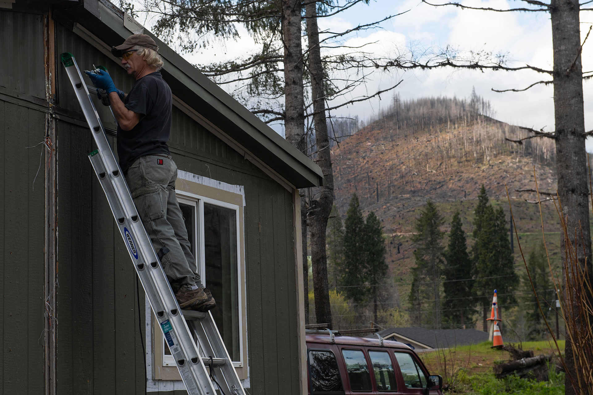 With burned McKenzie River Valley hillsides looming nearby, Andrew finishes connecting the two parts of their new home. While they will be living in their new house in a matter of months, it will be many years before the fire-damaged landscape recovers its former beauty. Andrew says living a rural lifestyle in a place like Blue River is invaluable. “I know that it’s been challenging. But, you know, at the end of the day, this is where I get to be. And to me, that’s worth it,” Andrew said.