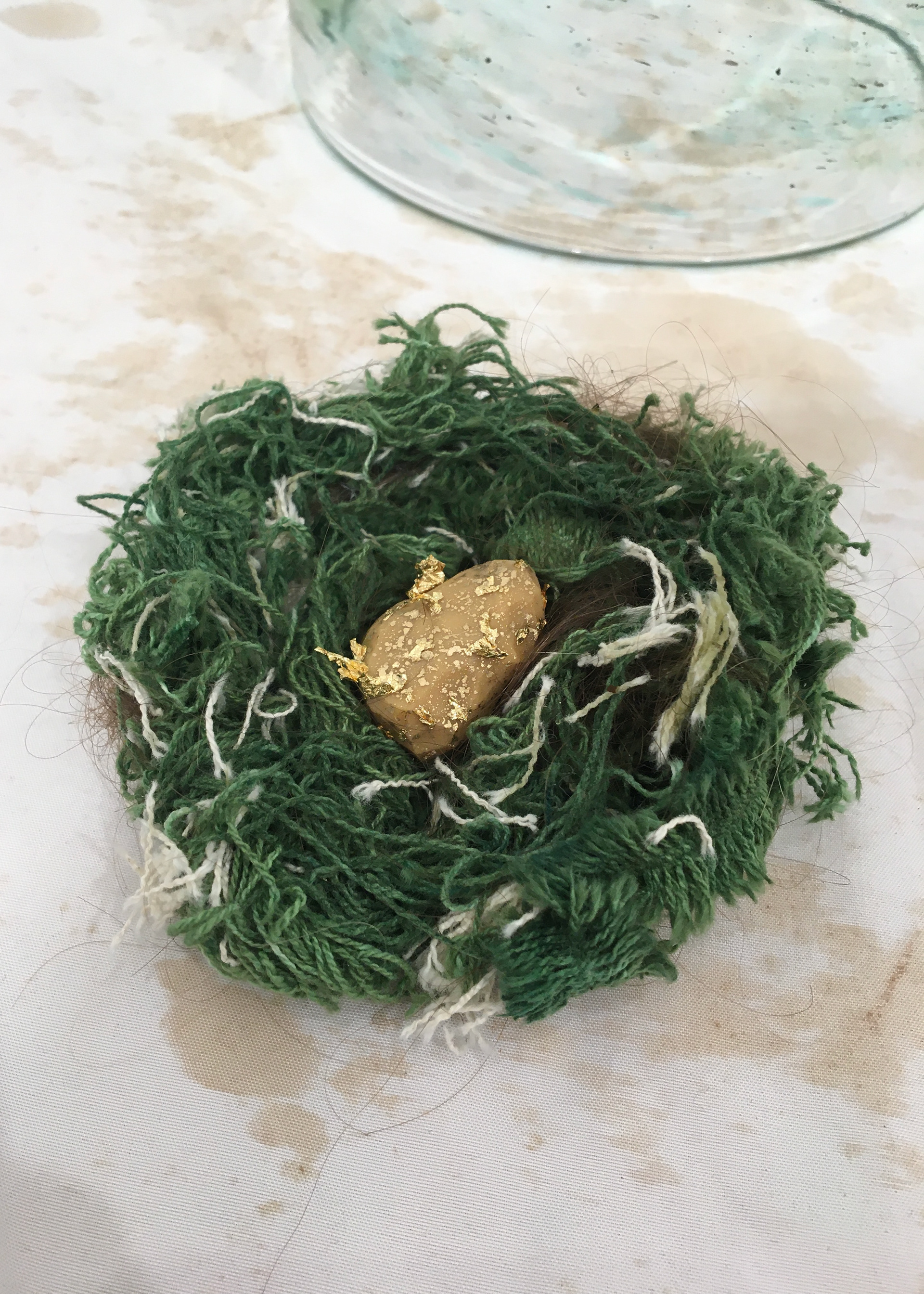 Spring: an emerald nest of canvas threads & human hair, a gilded egg of sorts nestled in its heart