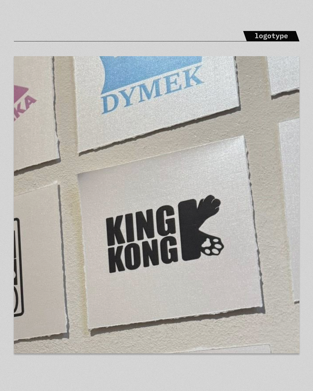 Minimalistyczna prezentacja brandingu w druku (print design). Logotyp "KING KONG" wyeksponowany na kwadratowym formacie o widocznej fakturze papieru. Dowód dbałości o detale poligraficzne i umiejętności przenoszenia tożsamości cyfrowej marki na fizyczne nośniki reklamowe.