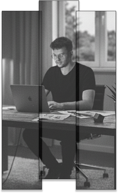 Portret Przemysława Riedla przy pracy. Czarno-białe zdjęcie przedstawiające grafika i stratega skupionego nad projektem przy laptopie. Wizerunek profesjonalnego freelancera w trakcie procesu twórczego, podkreślający zaangażowanie i dbałość o detale.