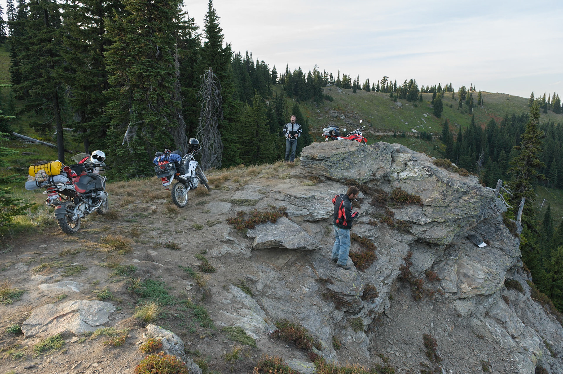 It was great to ride along the dirt road with the setting sun at our backs, miles of views and autumn colors painting the slopes around us. After some miles, we stopped to consider another campsite candidate.I noticed some shiny metal on the rocks and suggested Jesse should go check it out. He obliged, reporting it’s a memorial plaque for someone. Then he started yelling about a spider  and came scrambling back up like his hair was on fire, a big spider still hanging off him.