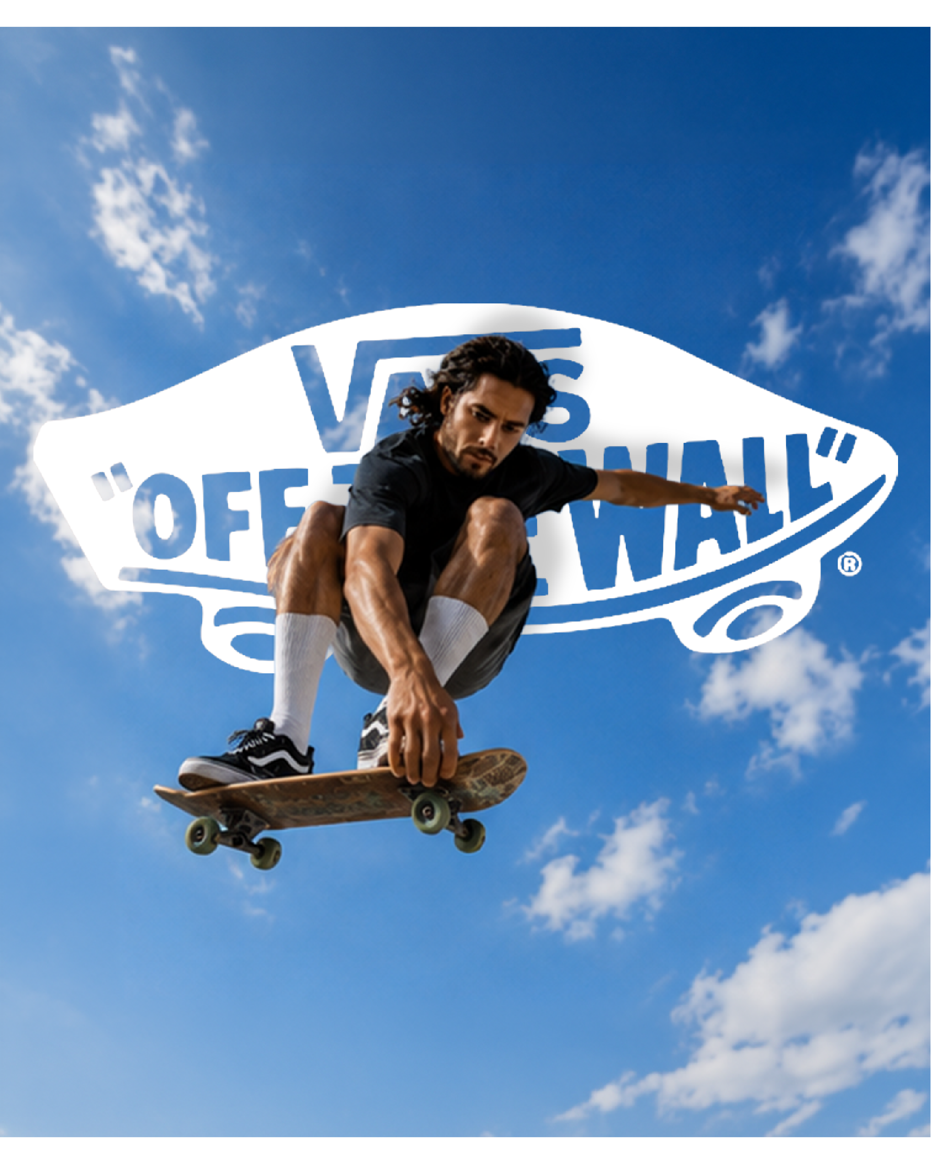Skater en el aire sujetando su tabla frente a un cielo azul.