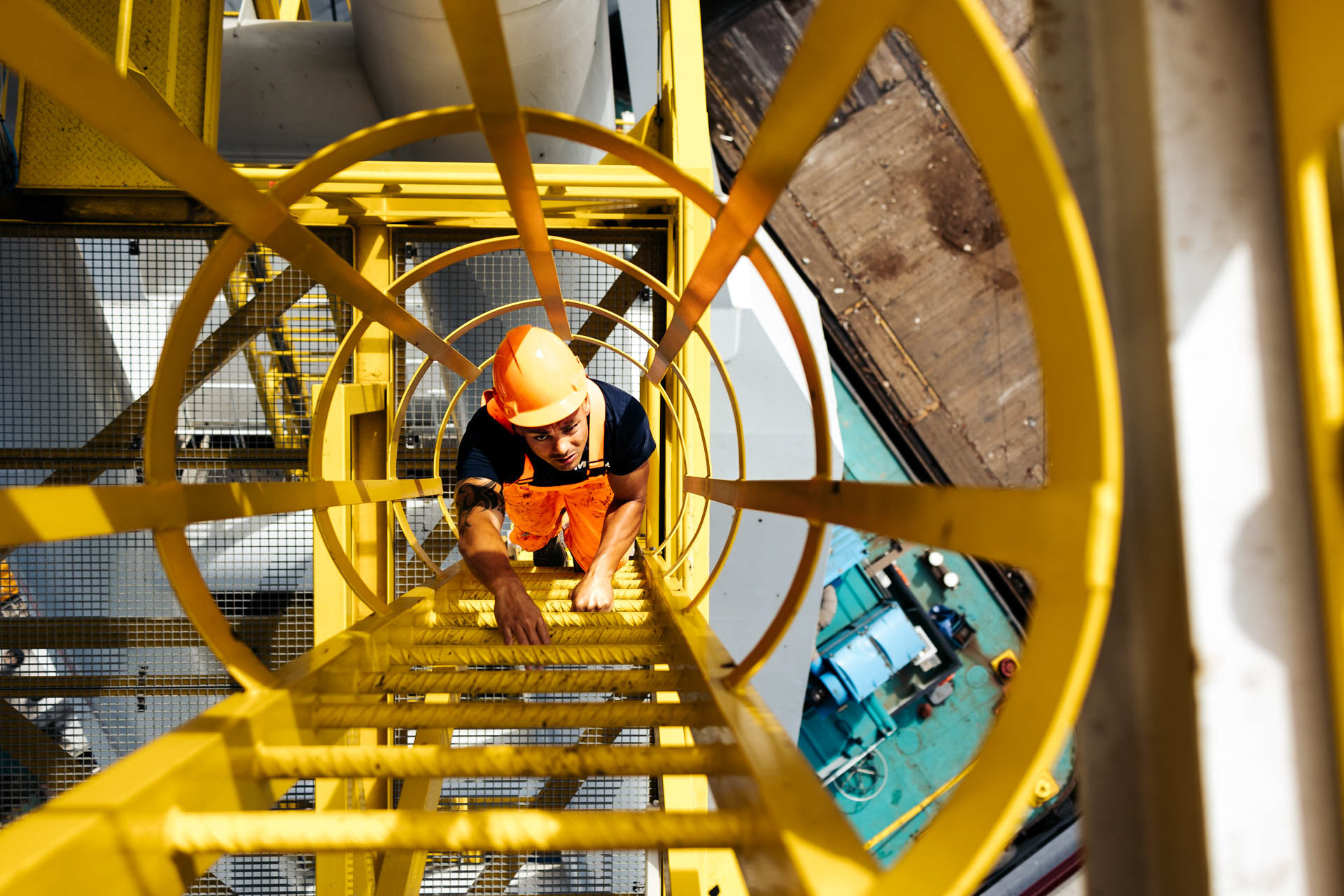 Industriele fotografie - kraanmachinst klimt omhoog in hijskraan