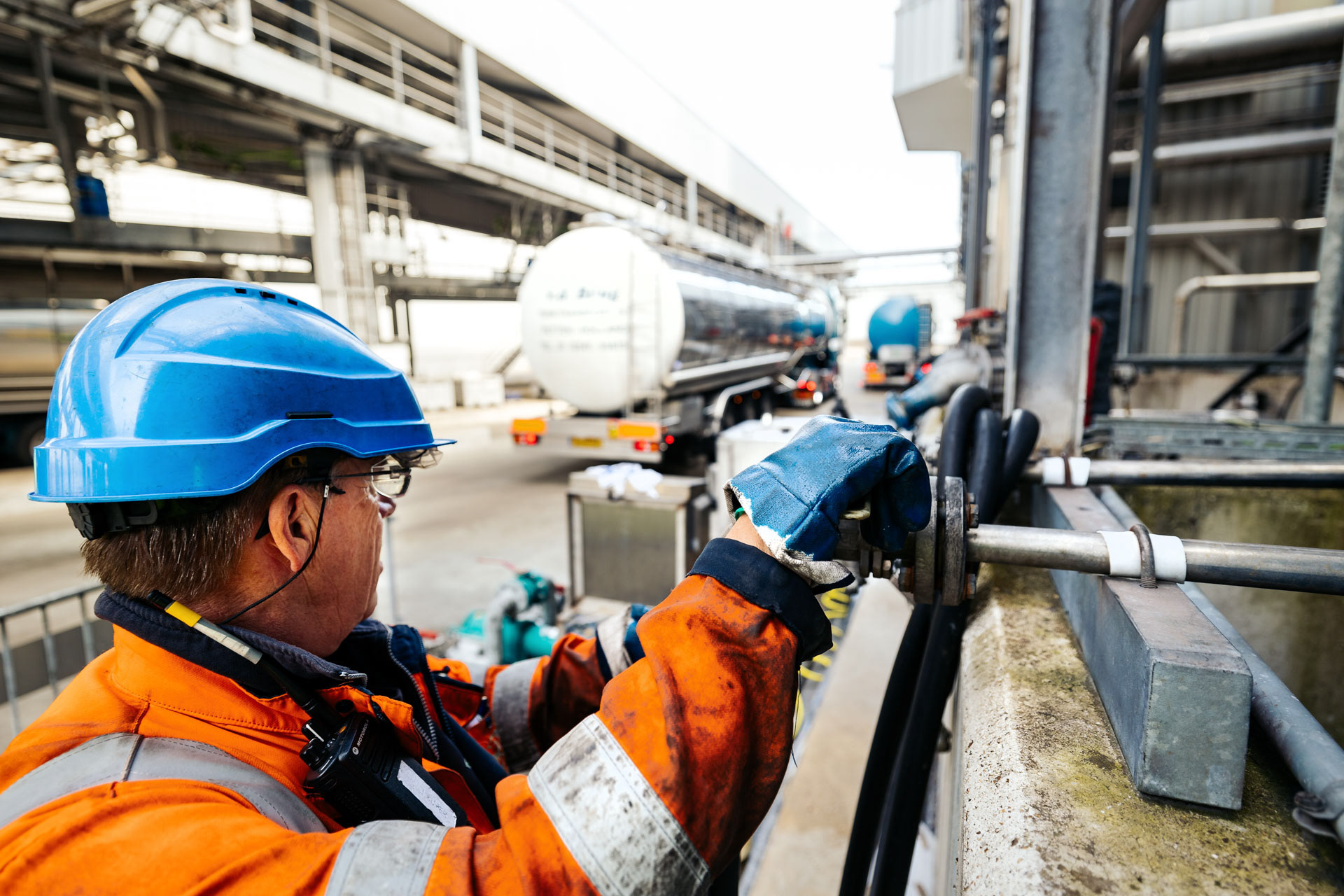 Vrachtwagenschauffeur laadt tankwagen in haven Amsterdam  - Industriële fotografie Jesse Kraal