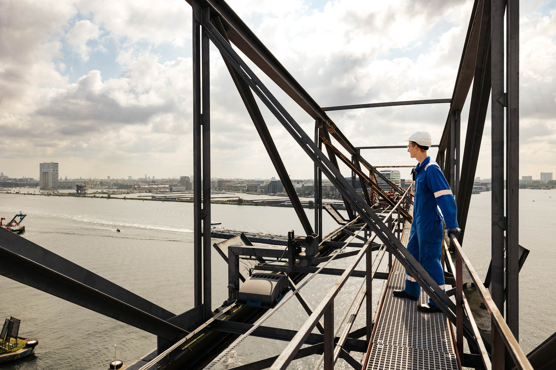 Industriele fotografie - kraanmachinst kijkt uit over amsterdamse haven