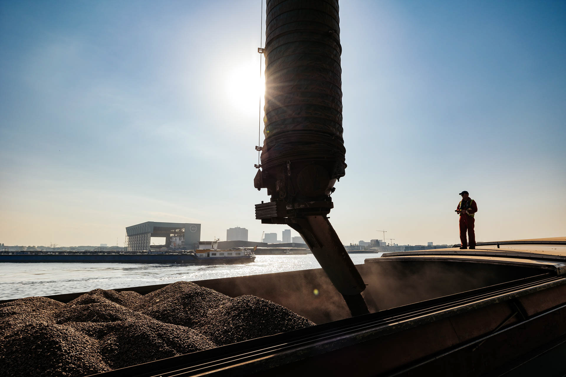 Industriele fotografie - Man lost cacaobonen in binnenvaartschip in haven Amsterdam