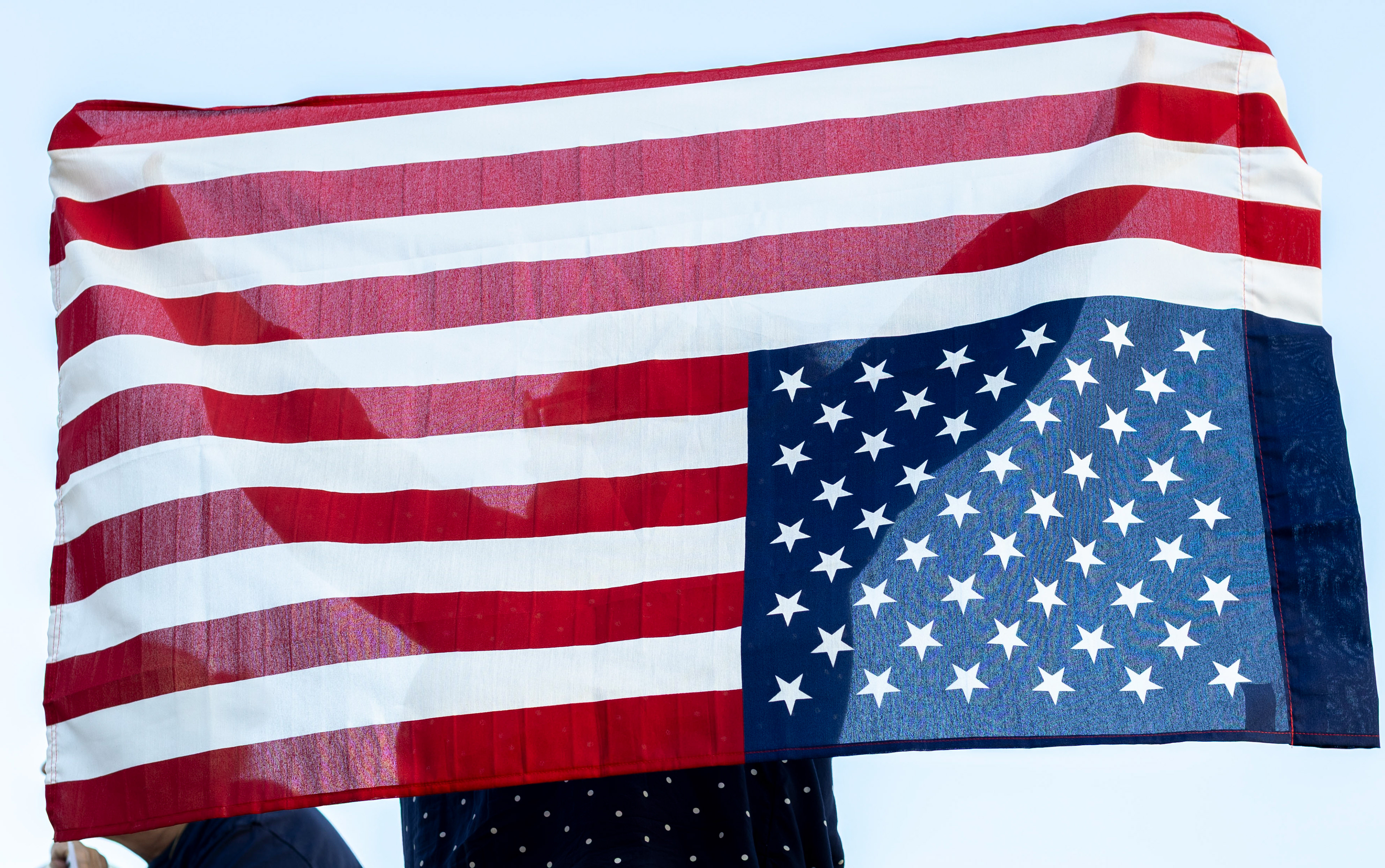 Arie Hamblin presents an upside down American flag to passing cars at a protest held by SoKy Indivisible outside of U.S. Rep. Brett Guthrie’s office on Thursday, Oct. 2, 2025. 