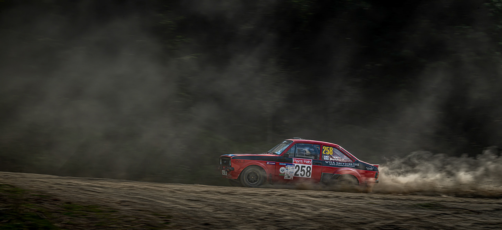 A MKII Ford Escort RS racing through the forest at the Plains Rally in North Wales.