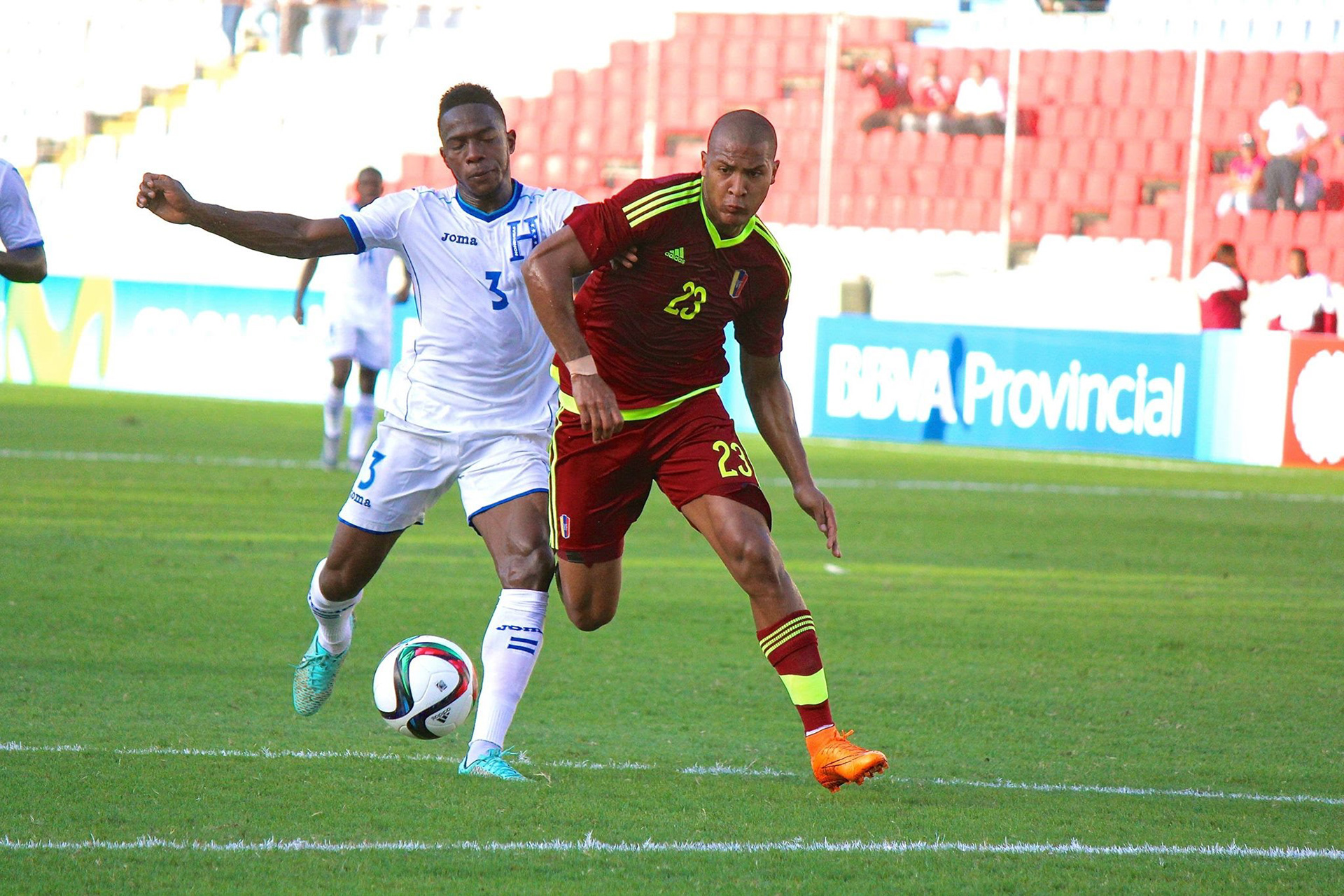 Salomón Rondón lucha un balón con un defensor de Honduras.