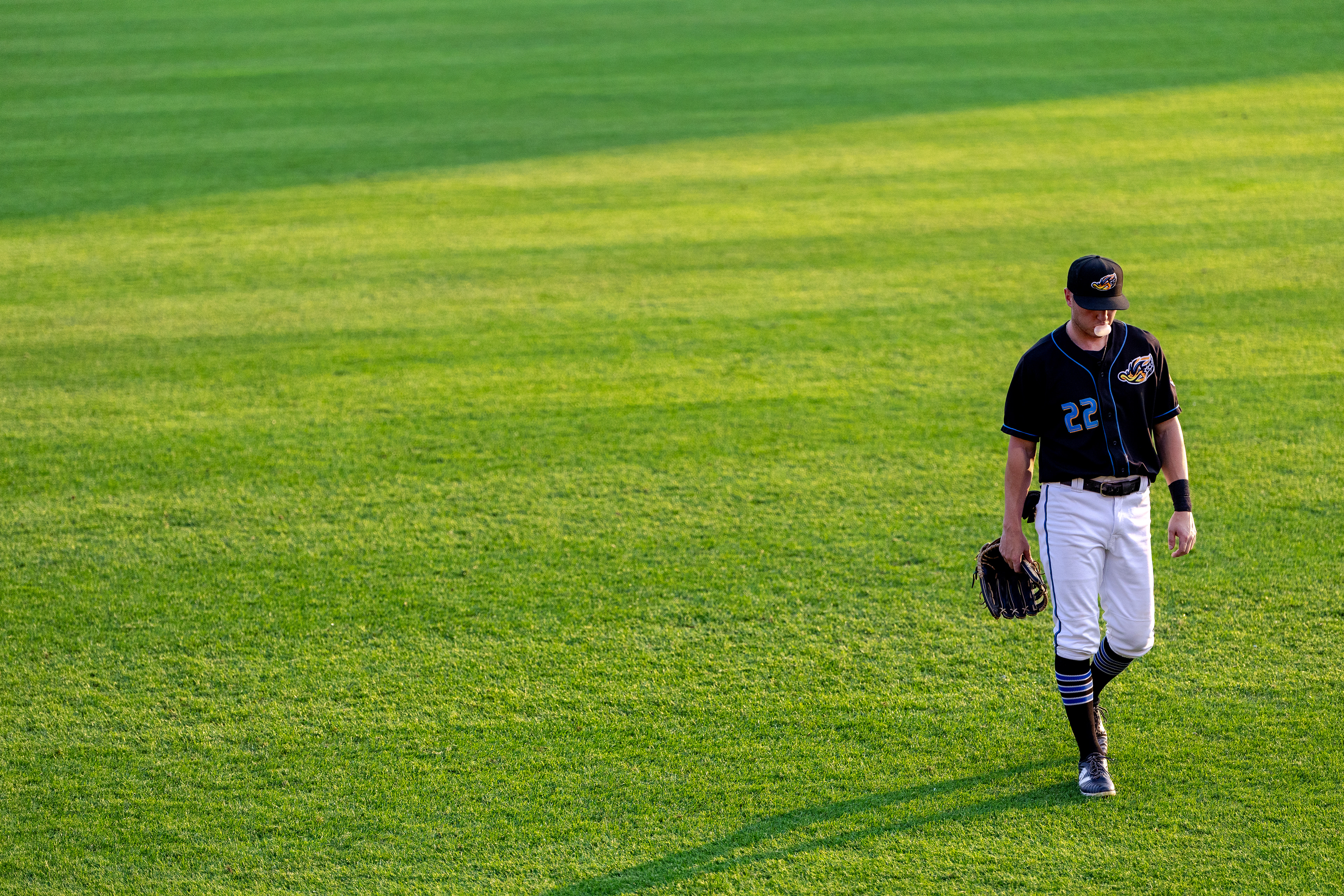 Akron Rubberducks #22, Joe Lampe, blows a bubble in the outfield during the game against the Chesapeake Baysox at Canal Park on August 9 2025.