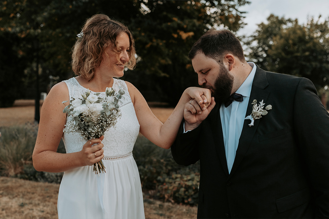 Bräutigam küsst die Hand seiner Braut