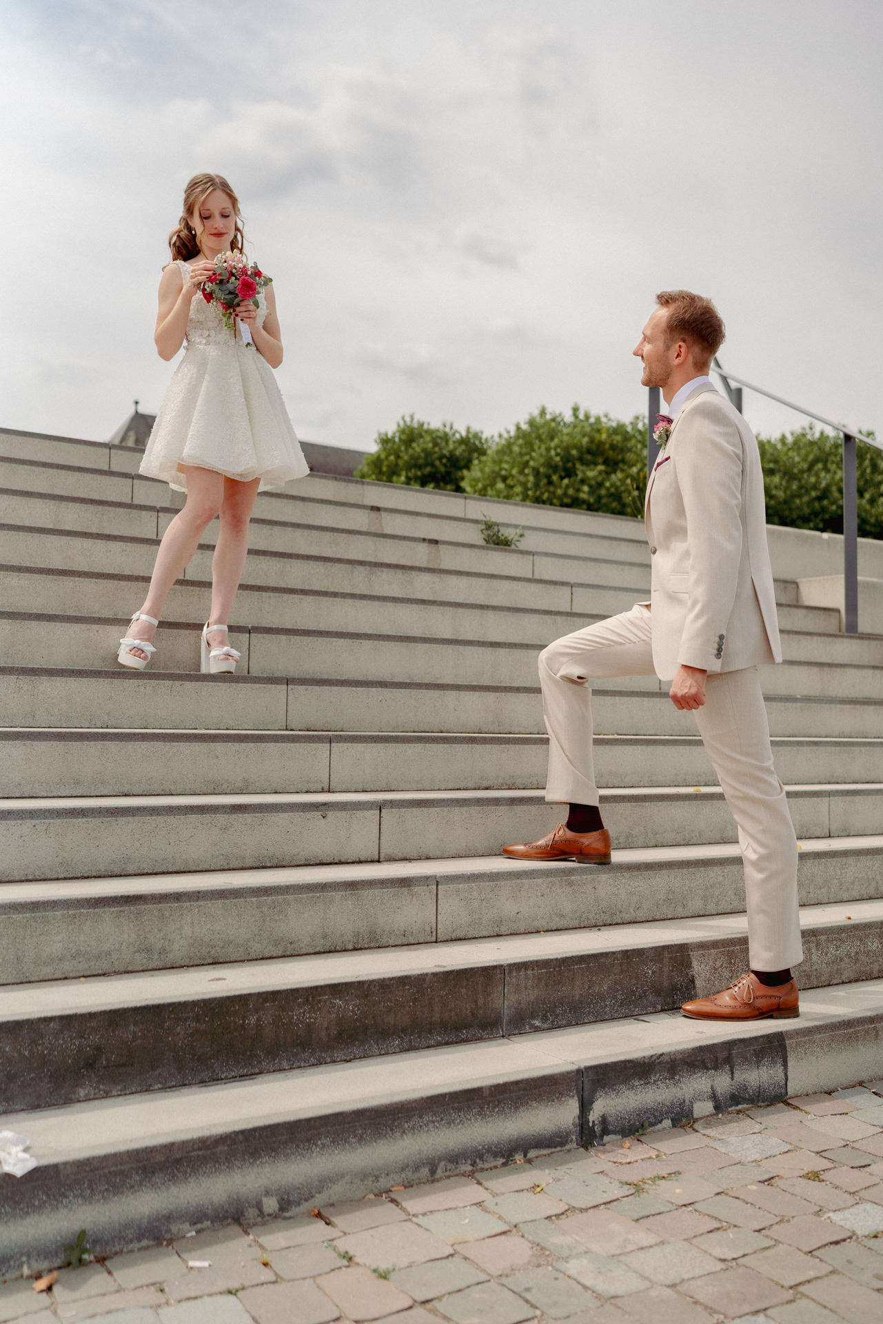 Braut und Bräutigam mit Blumenstrauß auf Treppen