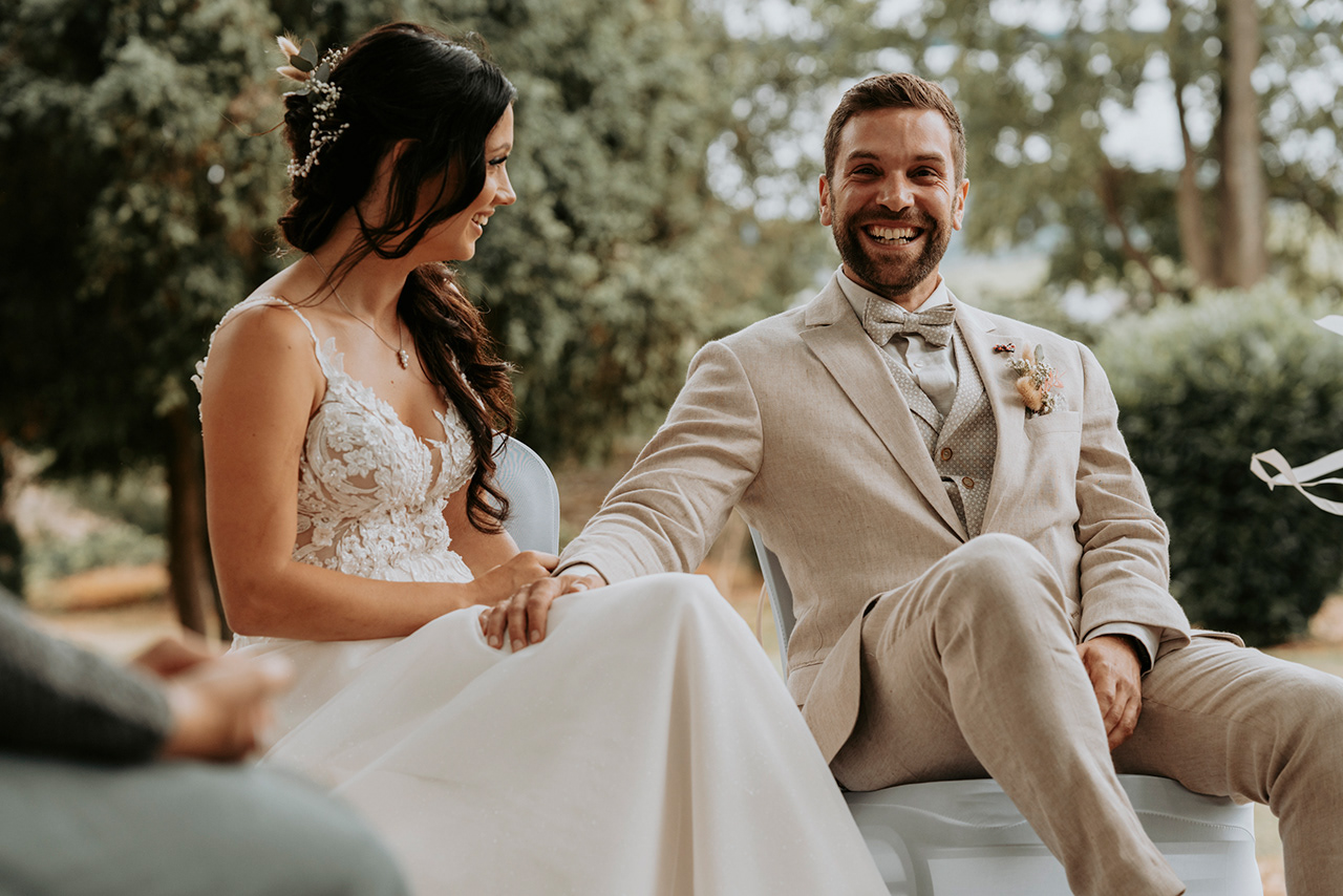 lachendes Hochzeitspaar während der Trauung