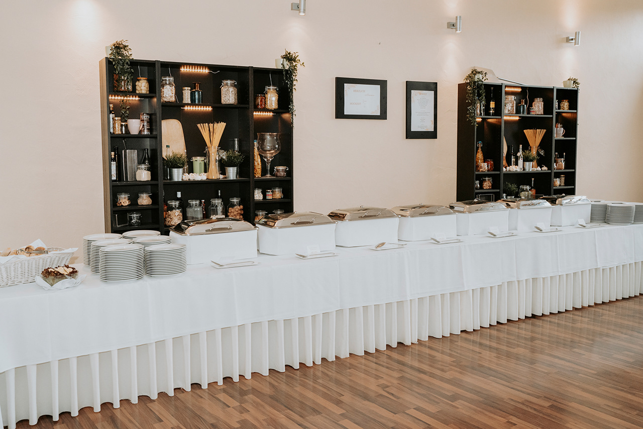 edles Buffet auf weißen Tischdecken bei der Hochzeit