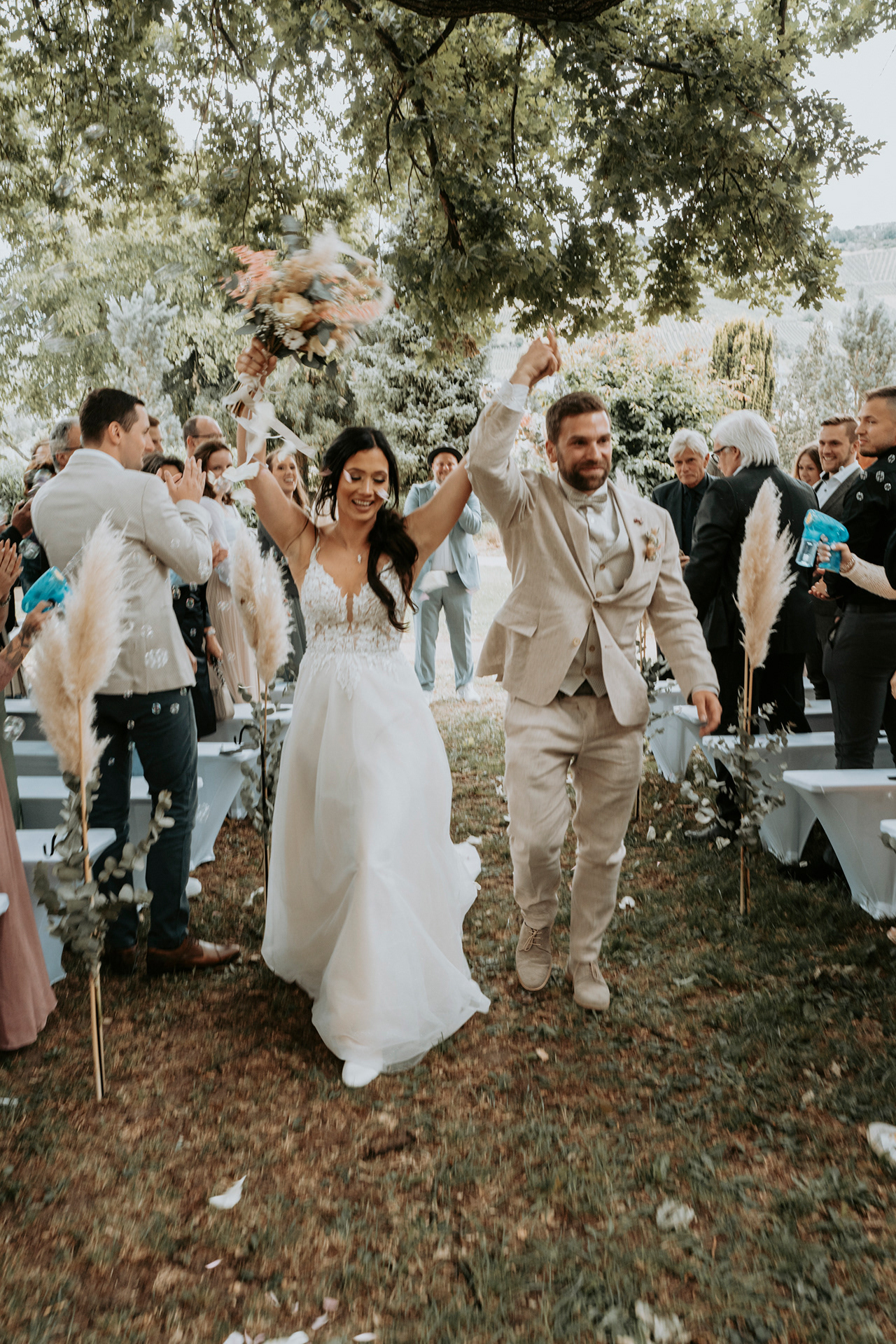 glückliches Hochzeitspaar nach der Trauung umgeben von Seifenblasen