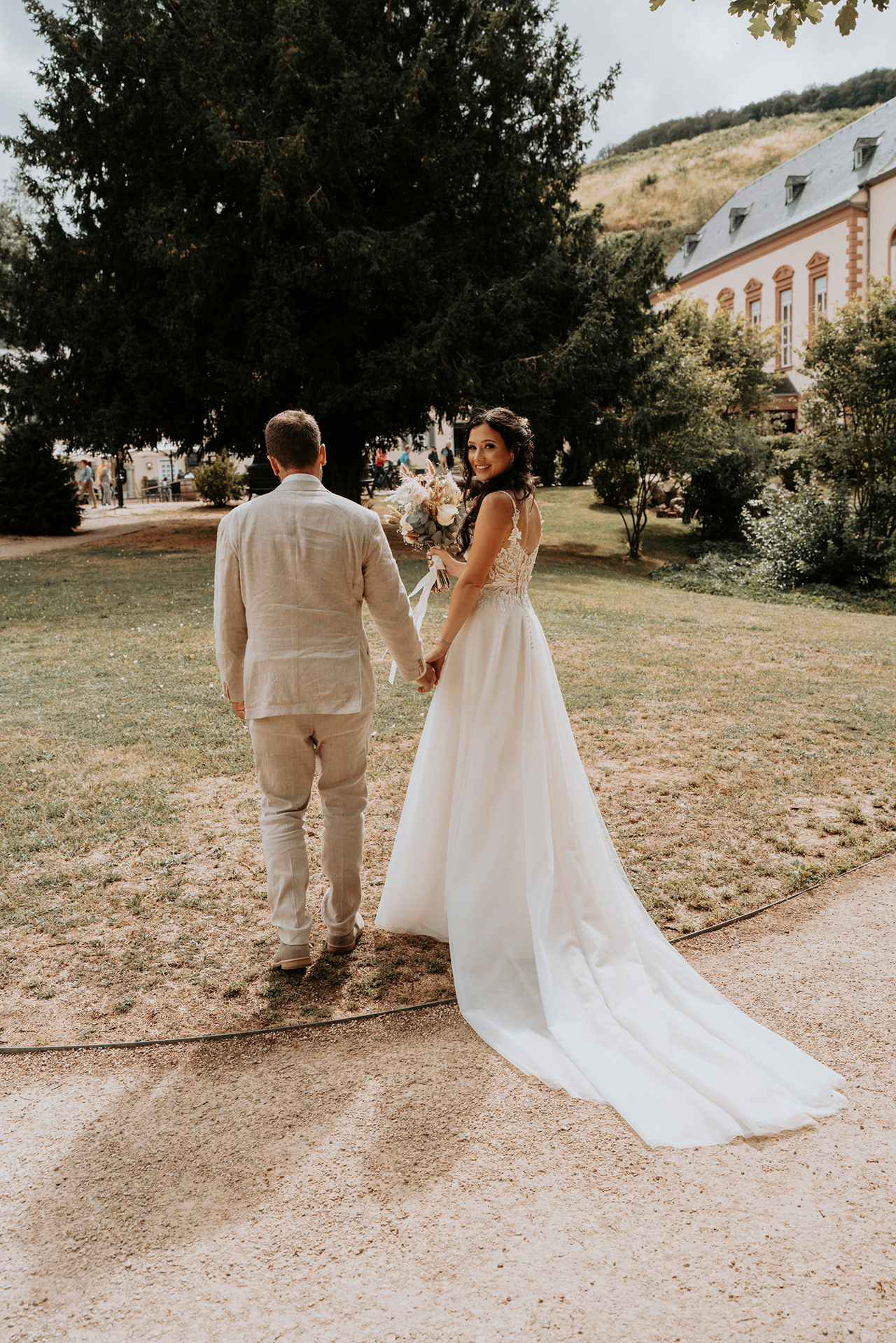 glückliche Braut blickt über die Schulter direkt in die Kamera