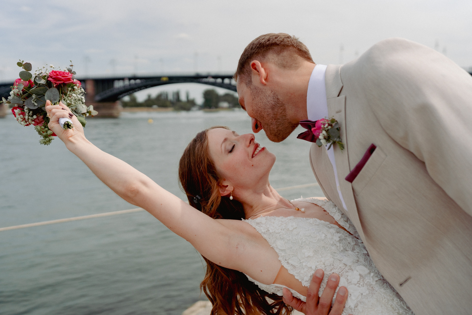 Hochzeitspaar in Tanzpose am Rhein