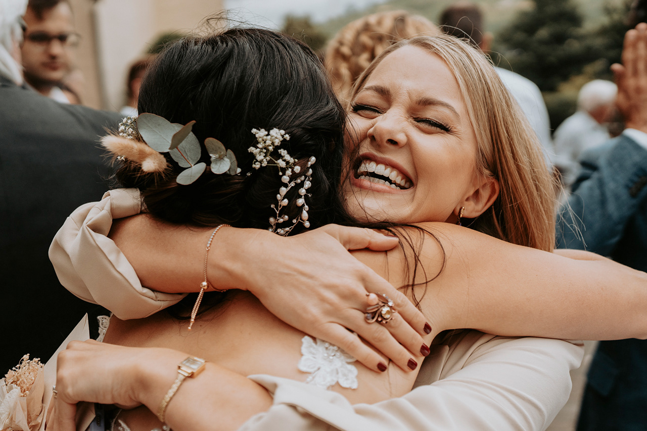 mega glückliche Umarmung der Braut mit einem Hochzeitsgast