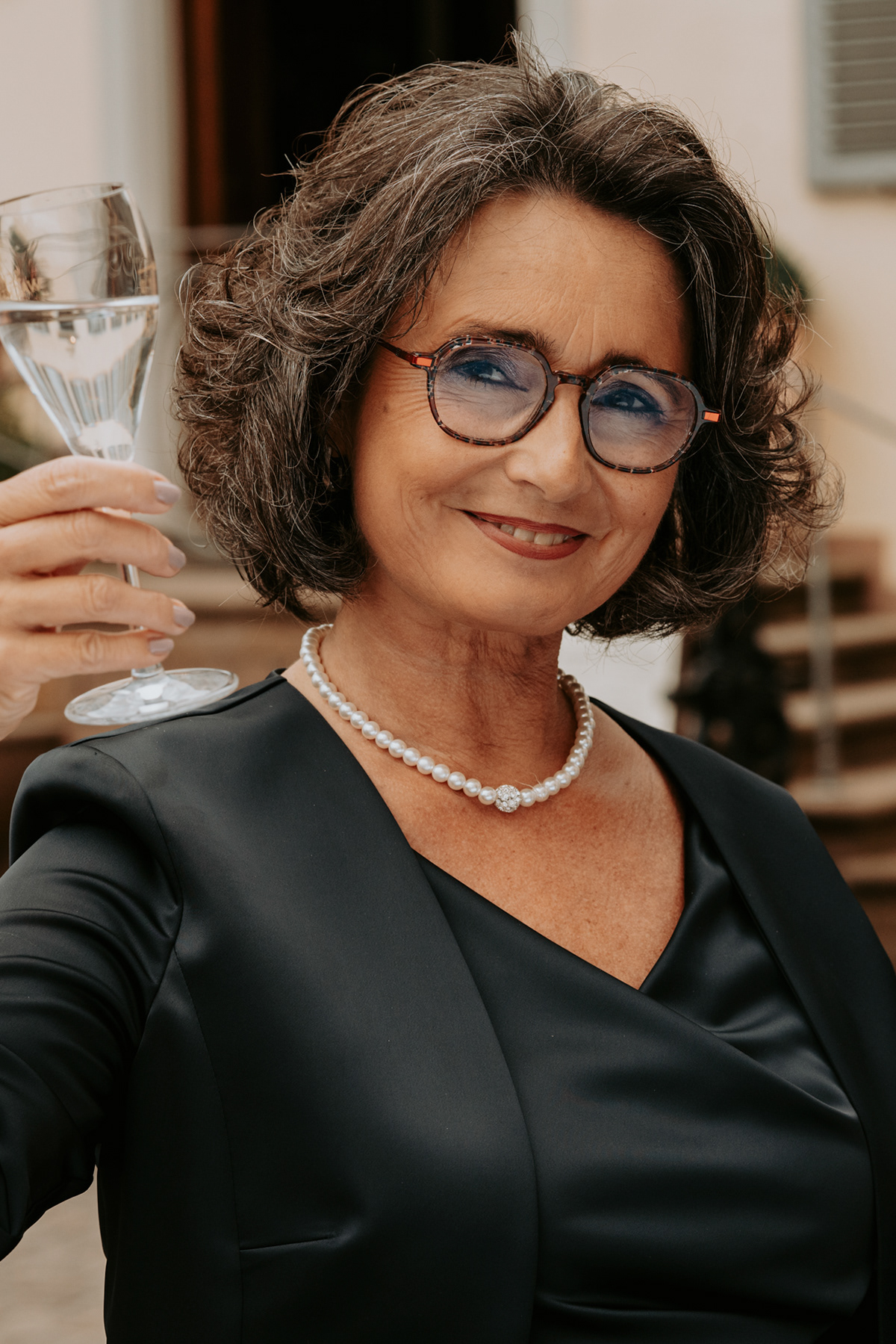 ältere hübsche Frau mit Brille und Weinglas