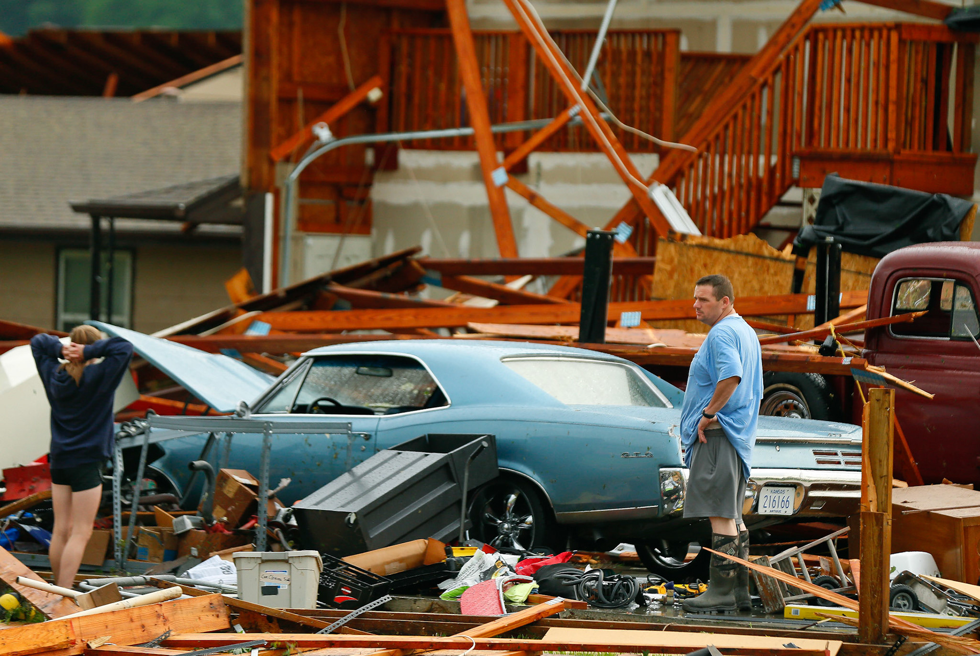 A man and woman inspect the damage to their home and classic cars after being hit by a tornado on Tuesday, May 28, 2019, in a neighborhood south of Lawrence, Kan., near US-59 highway and N. 1000 Road. [Chris Neal/The Capital-Journal]