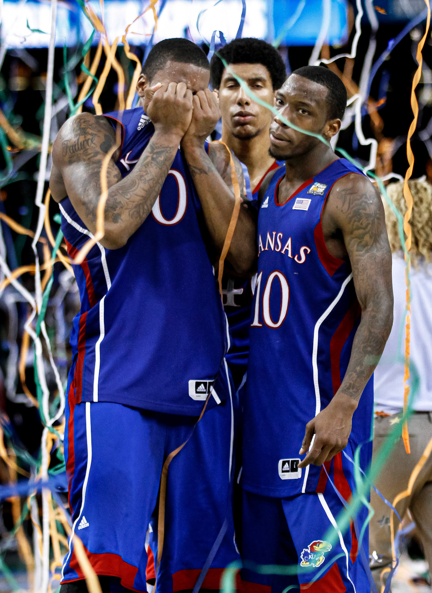Junior forward Thomas Robinson covers his face while being comforted by junior forward Kevin Young and senior guard Tyshawn Taylor after the Jayhawks were defeated by the Kentucky Wildcats in the NCAA Championship title game, 67-59.