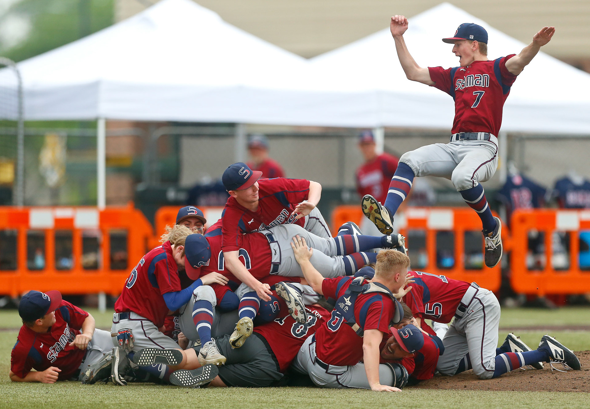 Seaman's Trent Cox, top right, flies in to participate in the Vikings dogpile after defeating St. Thomas Aquinas, 13-1, in the Class 5A state baseball championship game in Wichita, Kan.