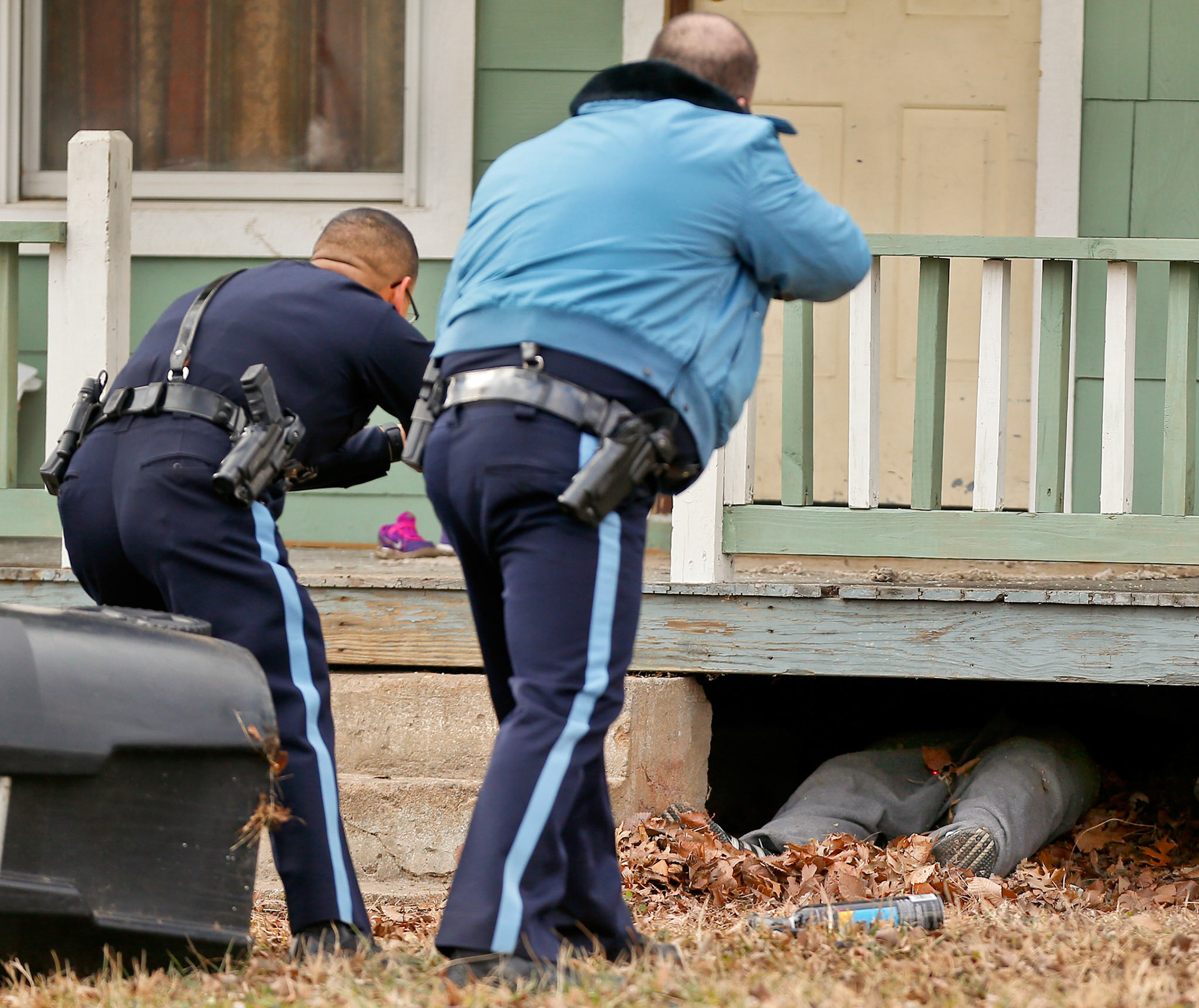 Capitol Police officers point tasers at a suspect that was caught hiding under a porch in the 1000 block of SE Hancock Thursday afternoon. (Chris Neal/The Capital-Journal)